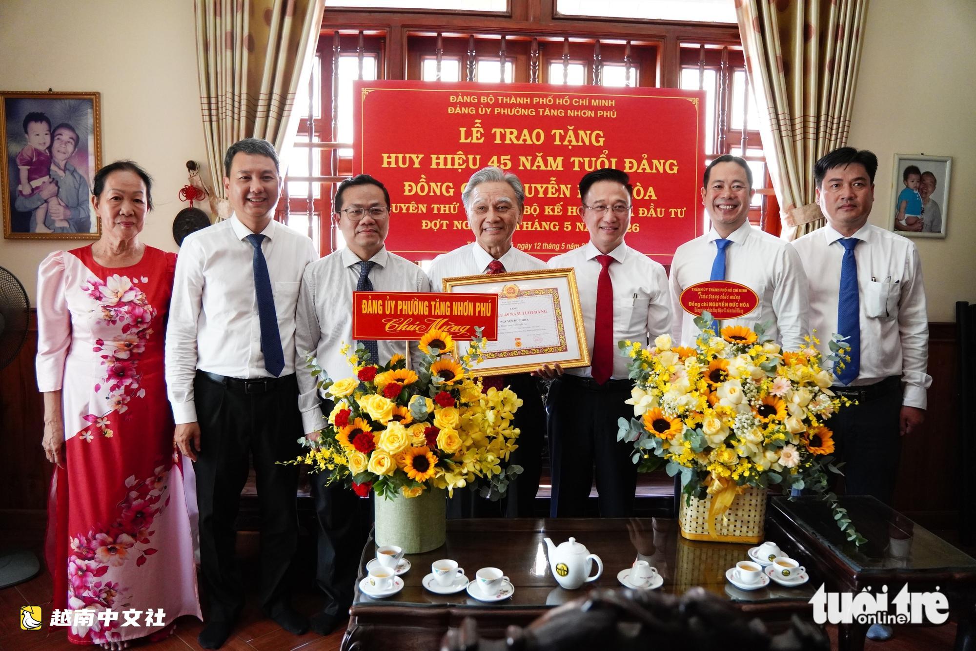 胡志明市領導向原計劃投資部副部長頒發45年黨齡徽章