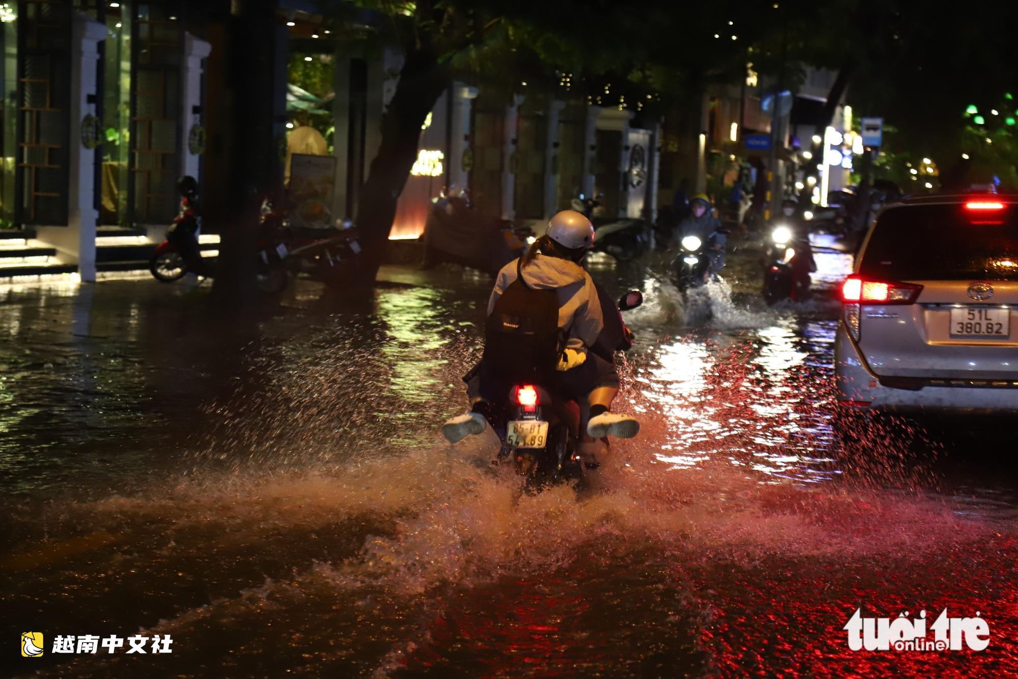 越南胡志明市大雨:春水路積水淹沒半輛摩托車