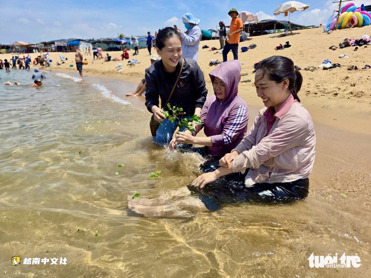 越南端午節正午海邊沐浴:民眾攜帶香葉,將海水帶回家