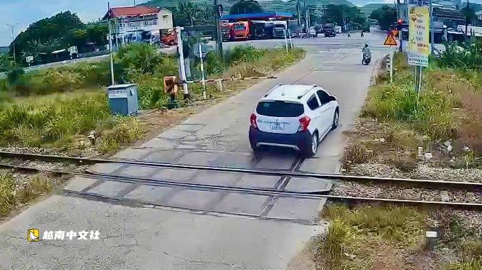 越南得樂省兩名司機在欄杆放下後駕車闖過被處罰