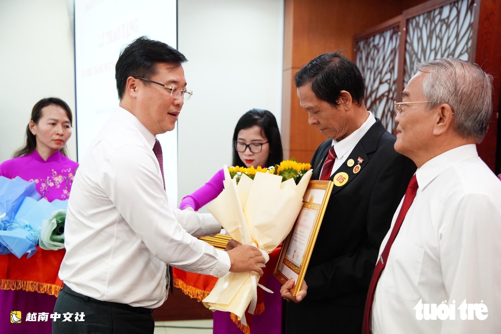 胡志明市市委領導在國慶節之際向老黨員頒發黨徽