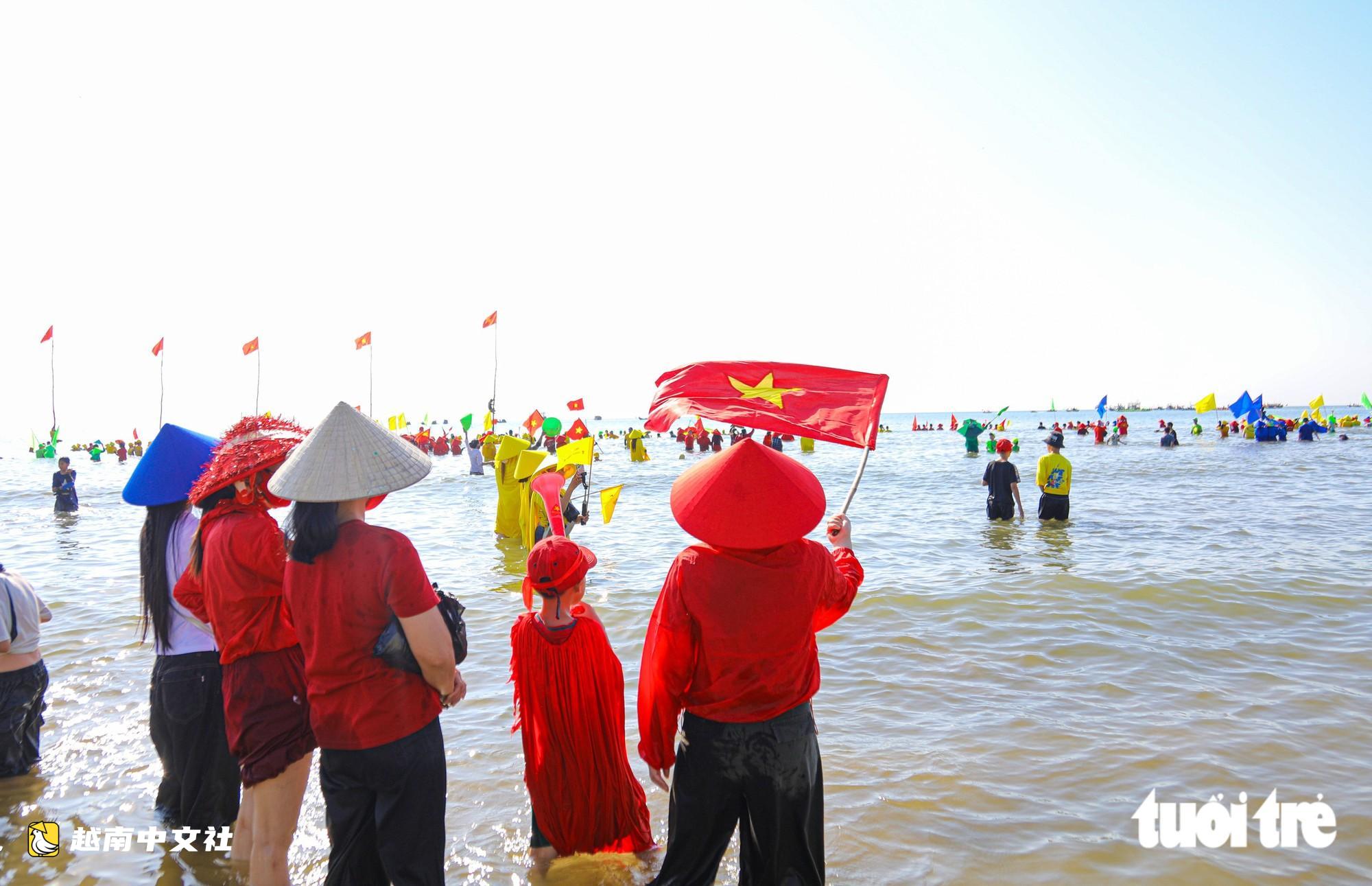 数千人下海为越南广治省渔村传统划船节助威