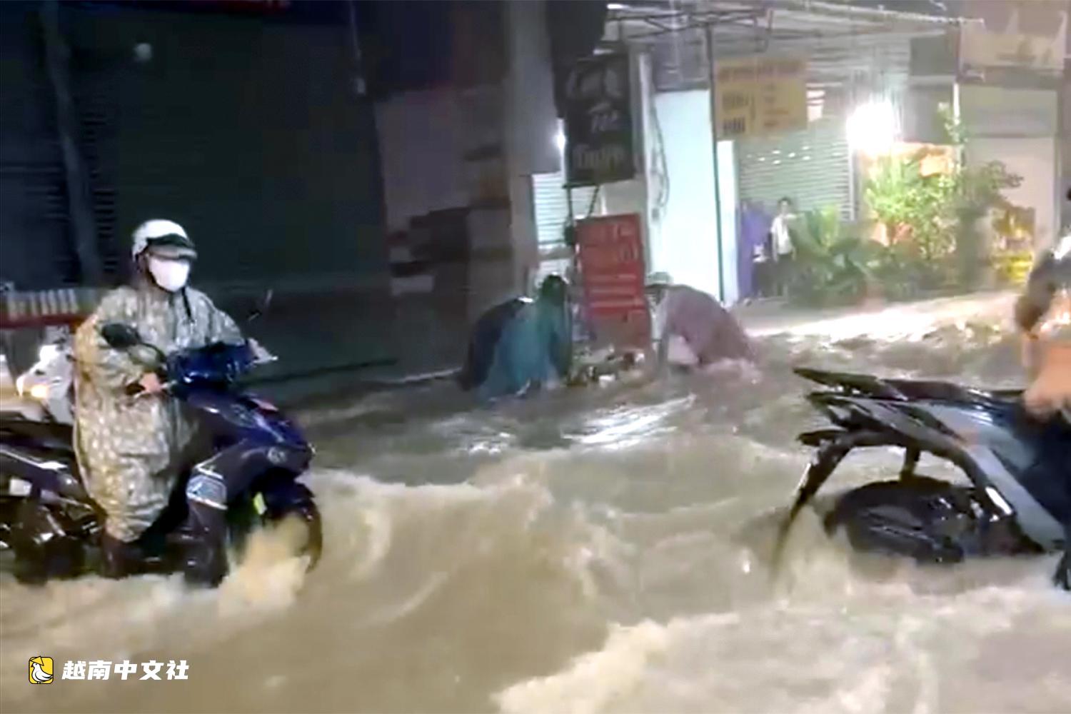 越南同奈省暴雨導致多條道路嚴重積水,摩托車被水流沖走