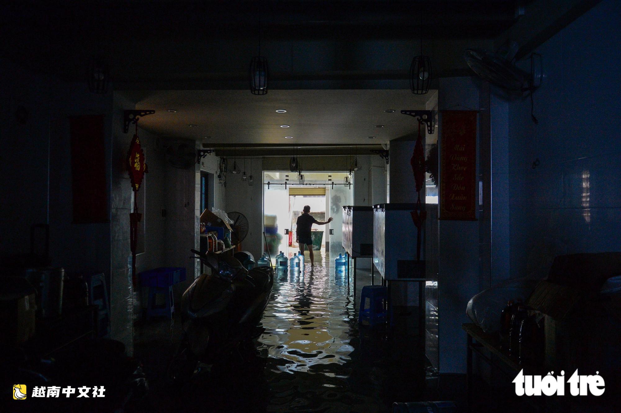 越南河內:每逢下雨就內澇的地方,居民用掃帚推垃圾、用木板擋水防漫進家中