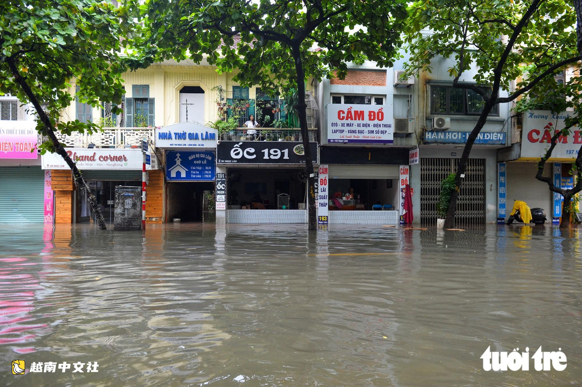 越南河內:每逢下雨就內澇的地方,居民用掃帚推垃圾、用木板擋水防漫進家中