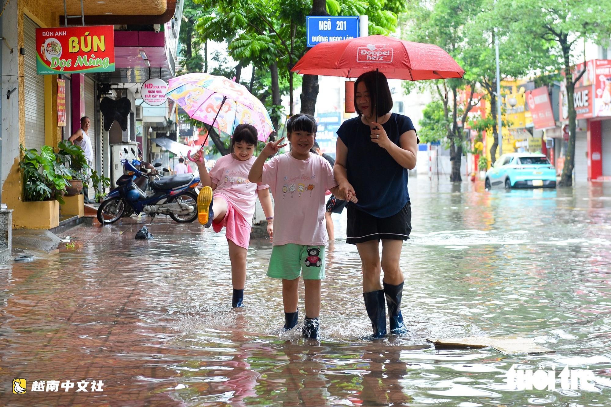 越南河內:每逢下雨就內澇的地方,居民用掃帚推垃圾、用木板擋水防漫進家中