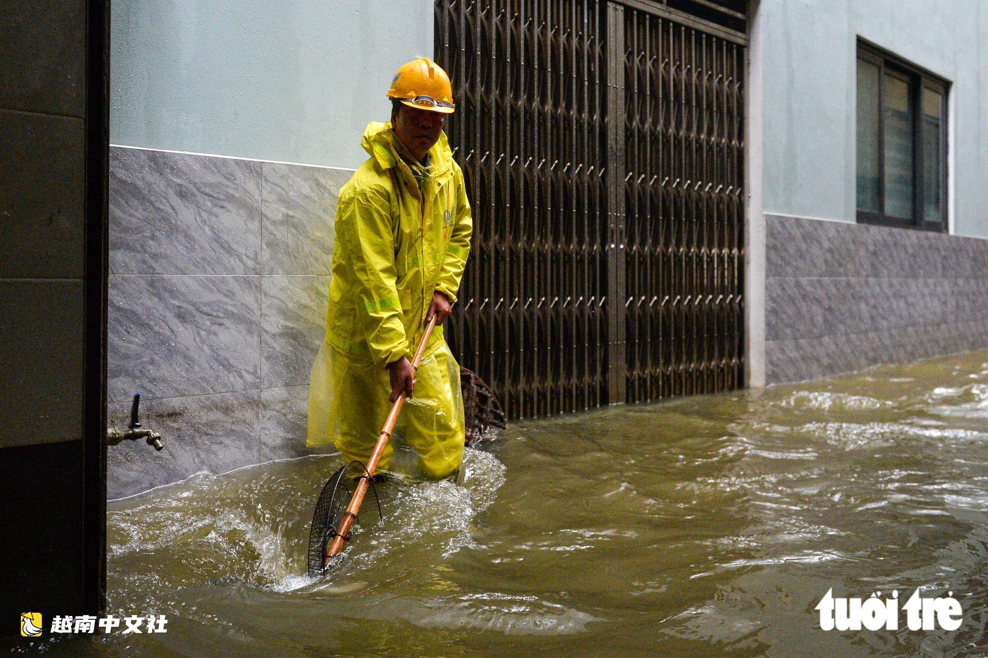 越南河內:每逢下雨就內澇的地方,居民用掃帚推垃圾、用木板擋水防漫進家中