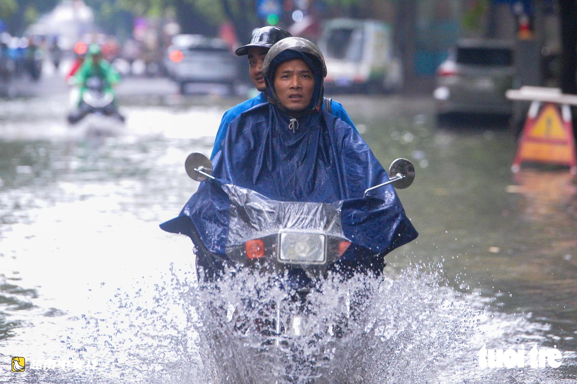 越南河內:每逢下雨就內澇的地方,居民用掃帚推垃圾、用木板擋水防漫進家中