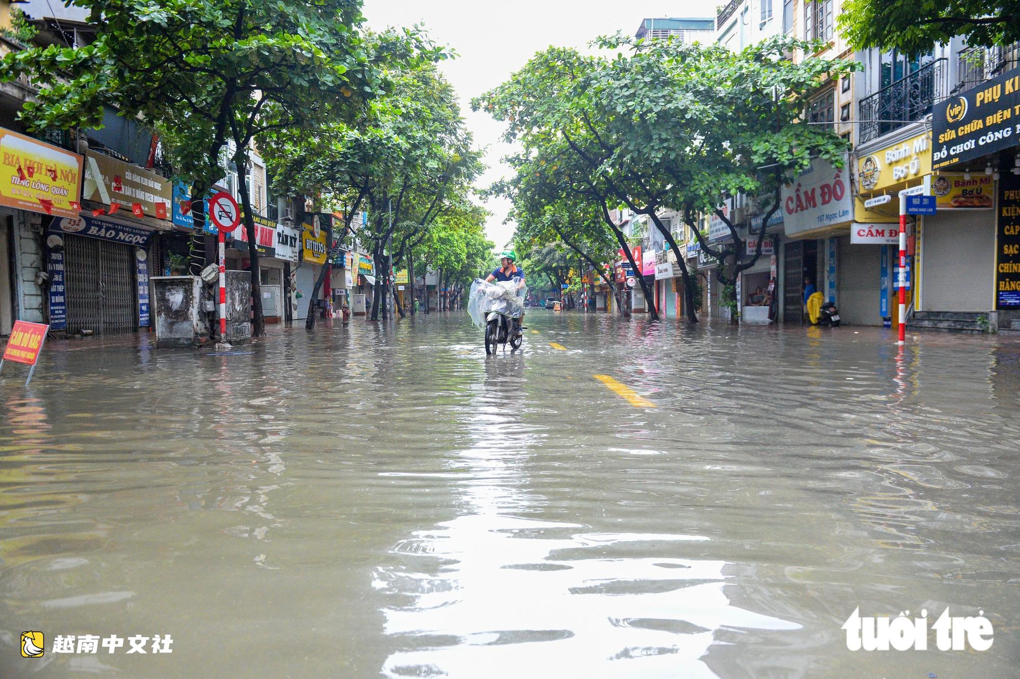 越南河內:每逢下雨就內澇的地方,居民用掃帚推垃圾、用木板擋水防漫進家中