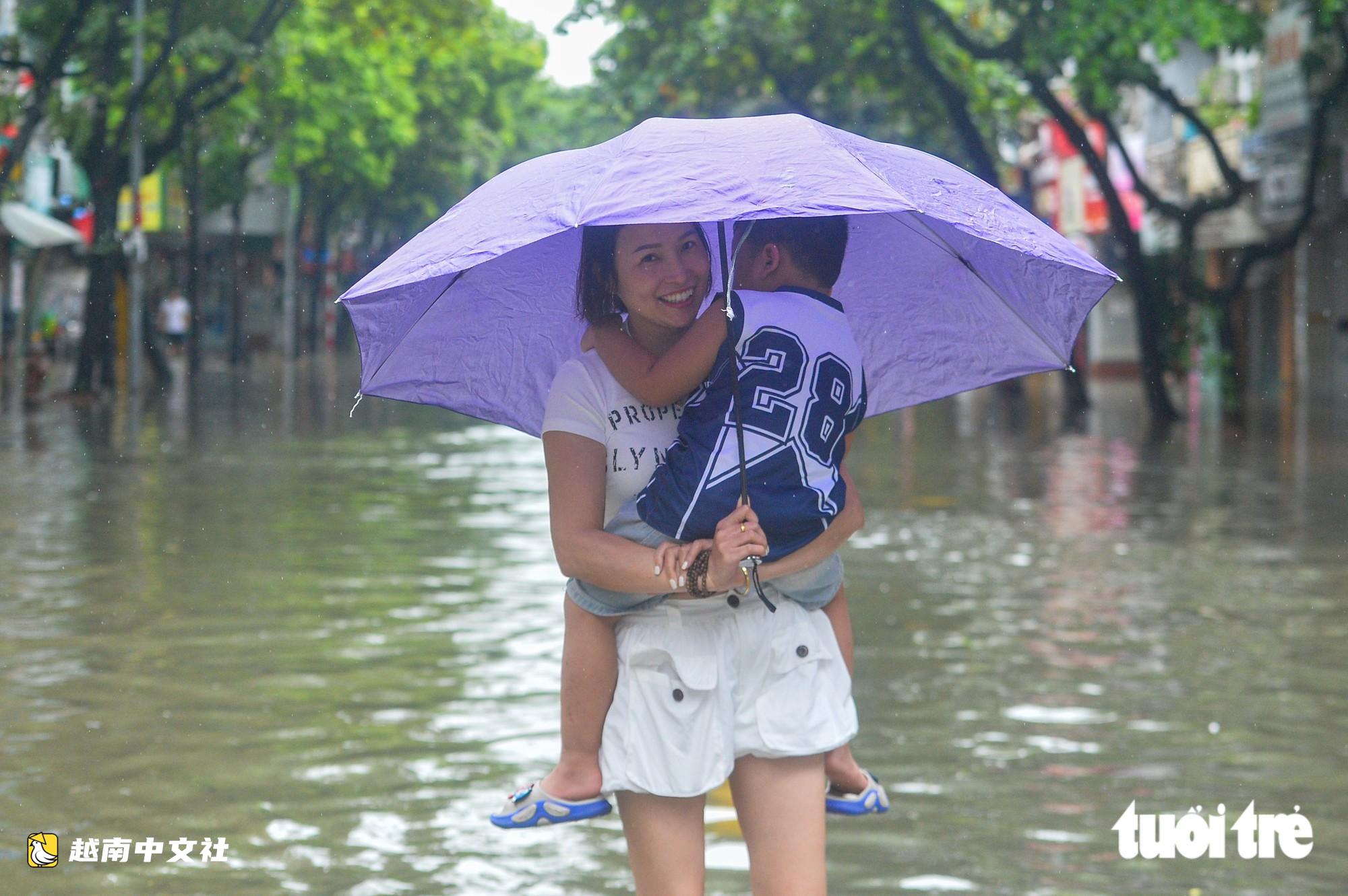 越南河內:每逢下雨就內澇的地方,居民用掃帚推垃圾、用木板擋水防漫進家中