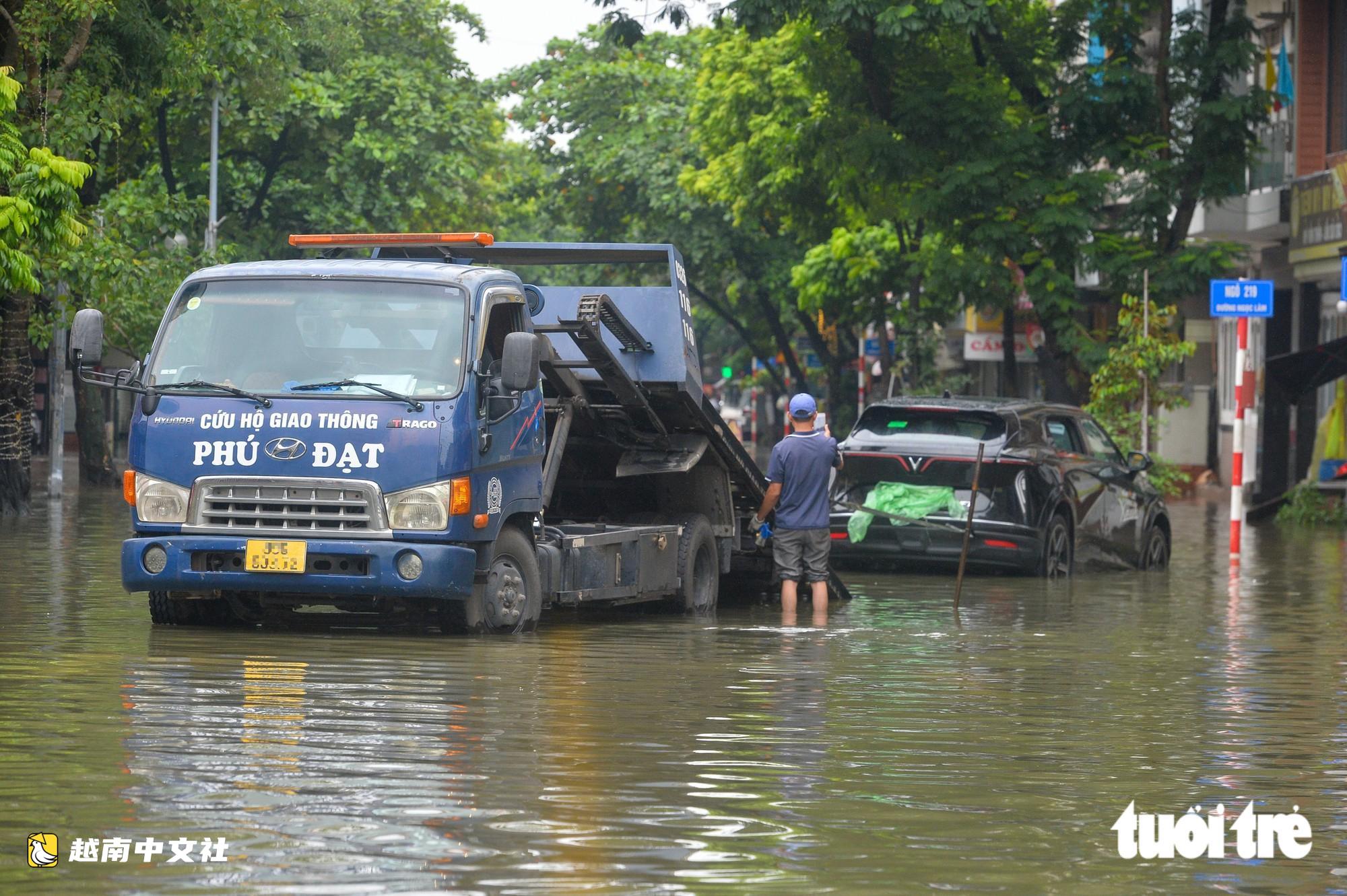 越南河內:每逢下雨就內澇的地方,居民用掃帚推垃圾、用木板擋水防漫進家中