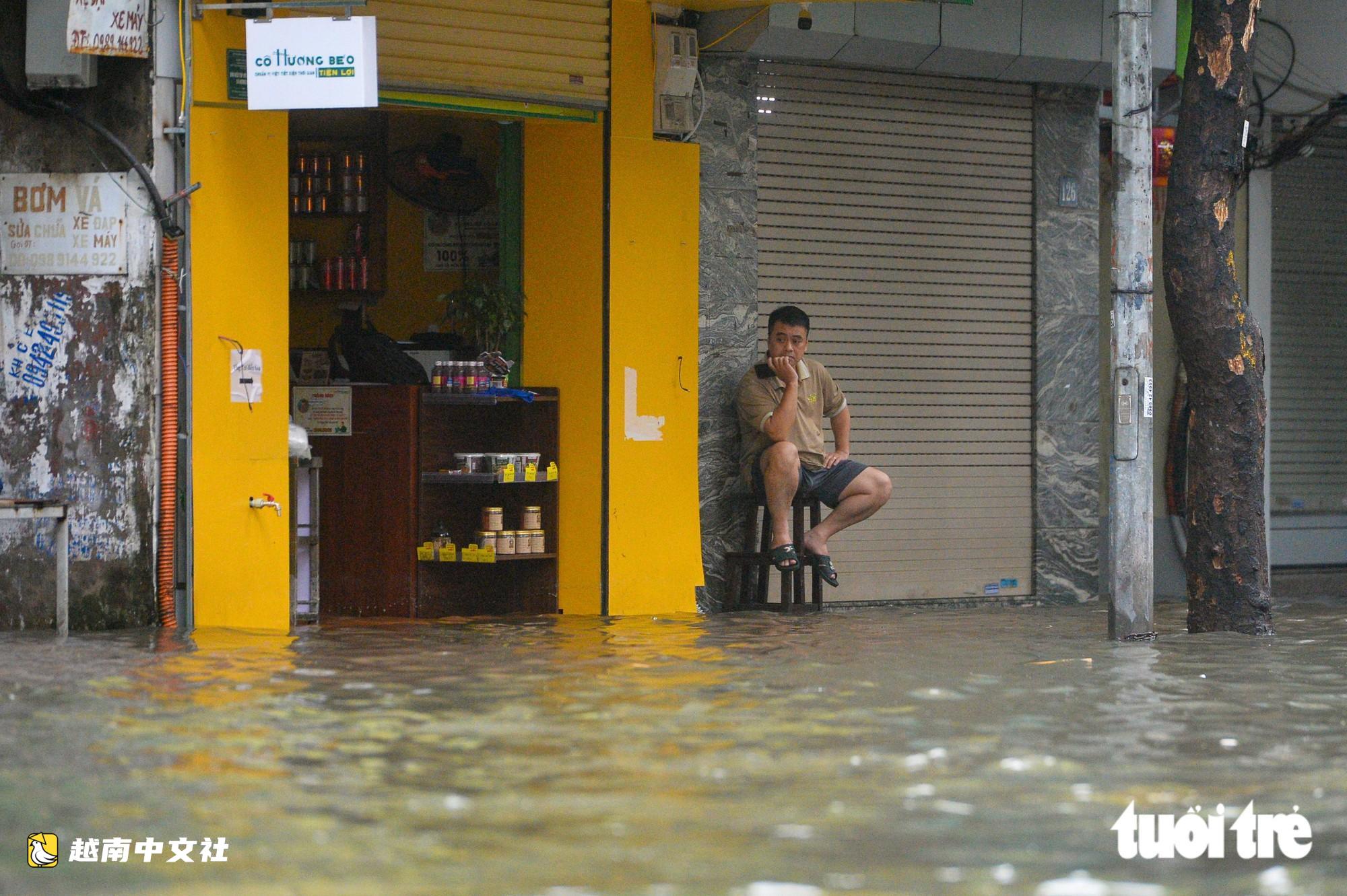 越南河內:每逢下雨就內澇的地方,居民用掃帚推垃圾、用木板擋水防漫進家中