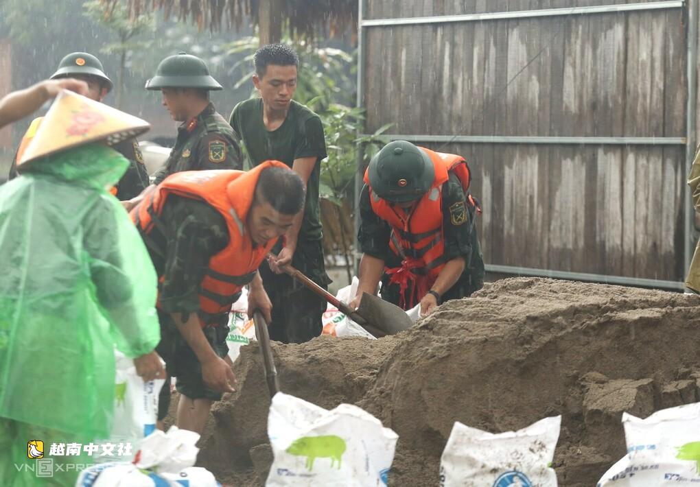 越南河內郊外數百人冒雨加固堤壩抗洪