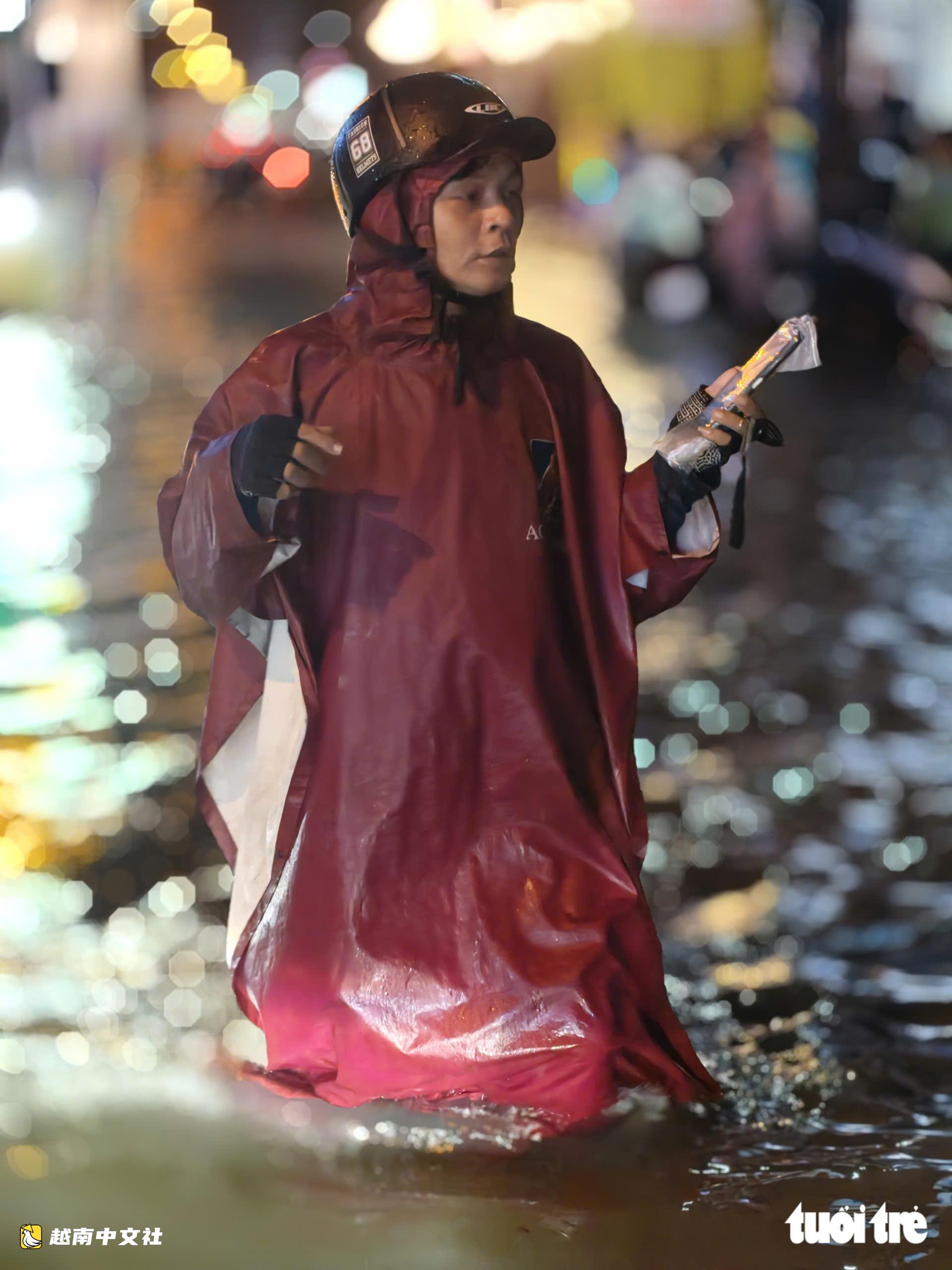 越南胡志明市:晚上22點,潘輝益路上摩托車成排熄火,民眾疲憊推車涉水回家