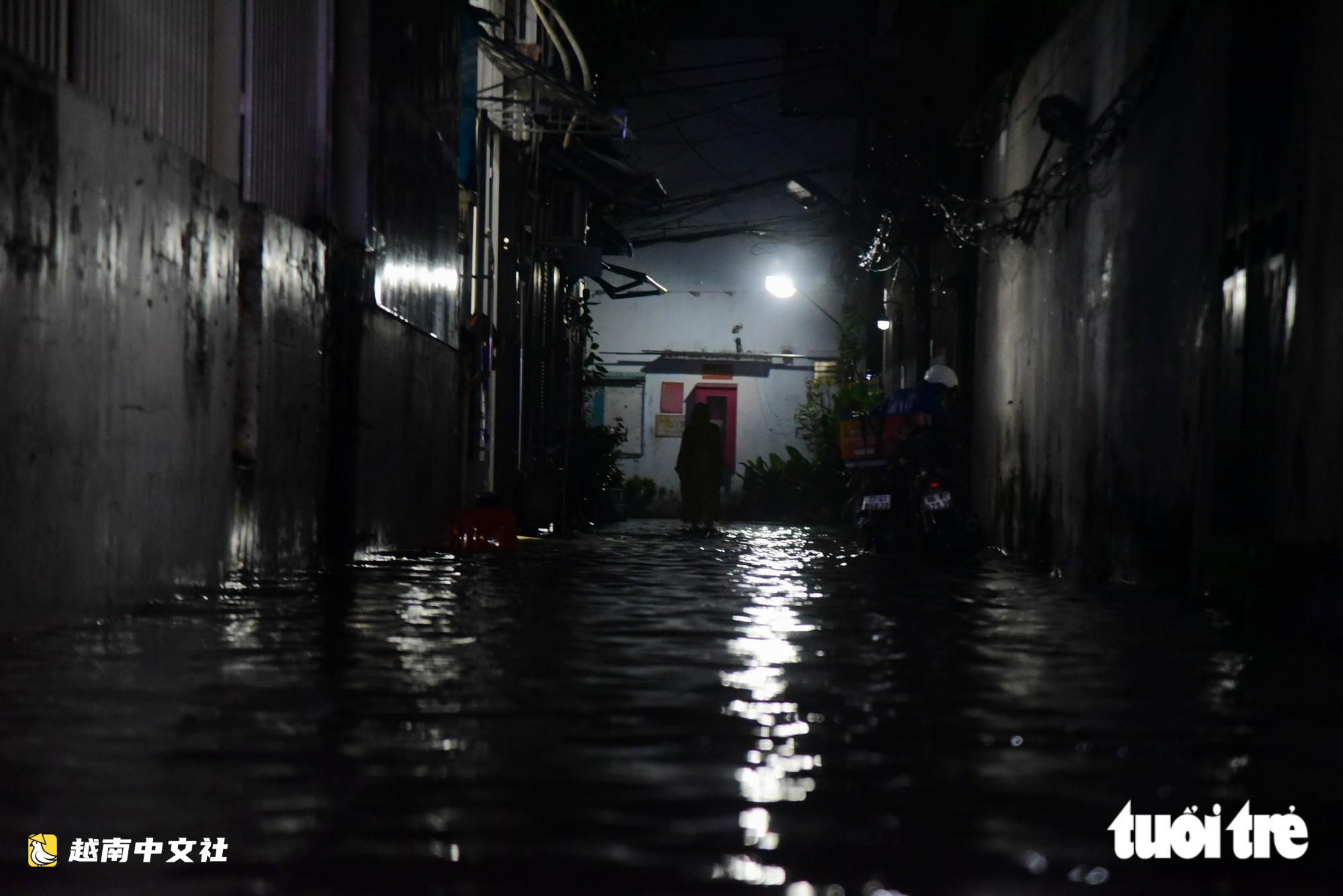 越南胡志明市:晚上22點,潘輝益路上摩托車成排熄火,民眾疲憊推車涉水回家
