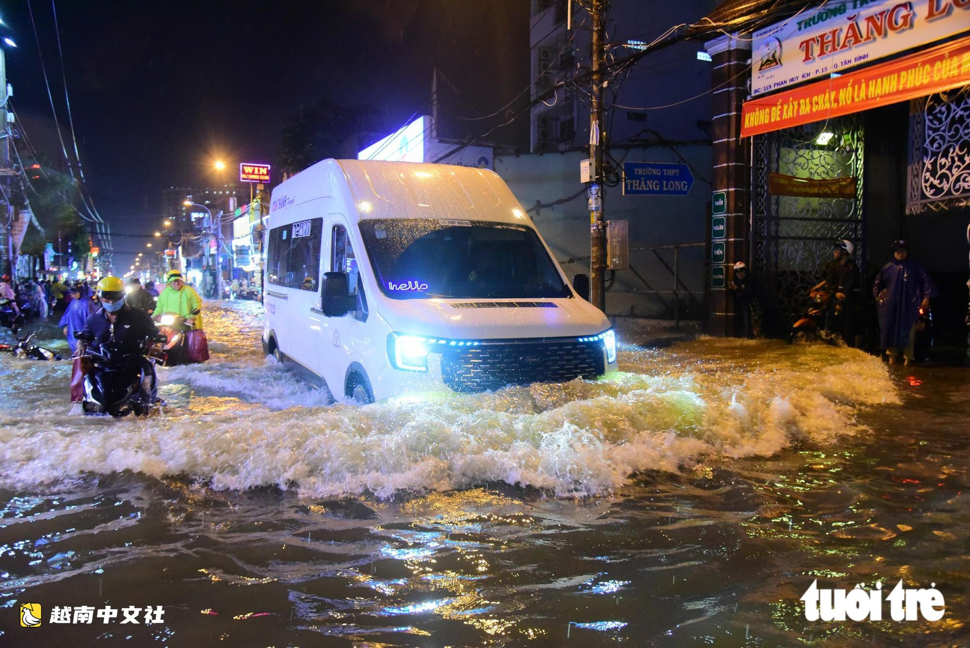 越南胡志明市:晚上22點,潘輝益路上摩托車成排熄火,民眾疲憊推車涉水回家
