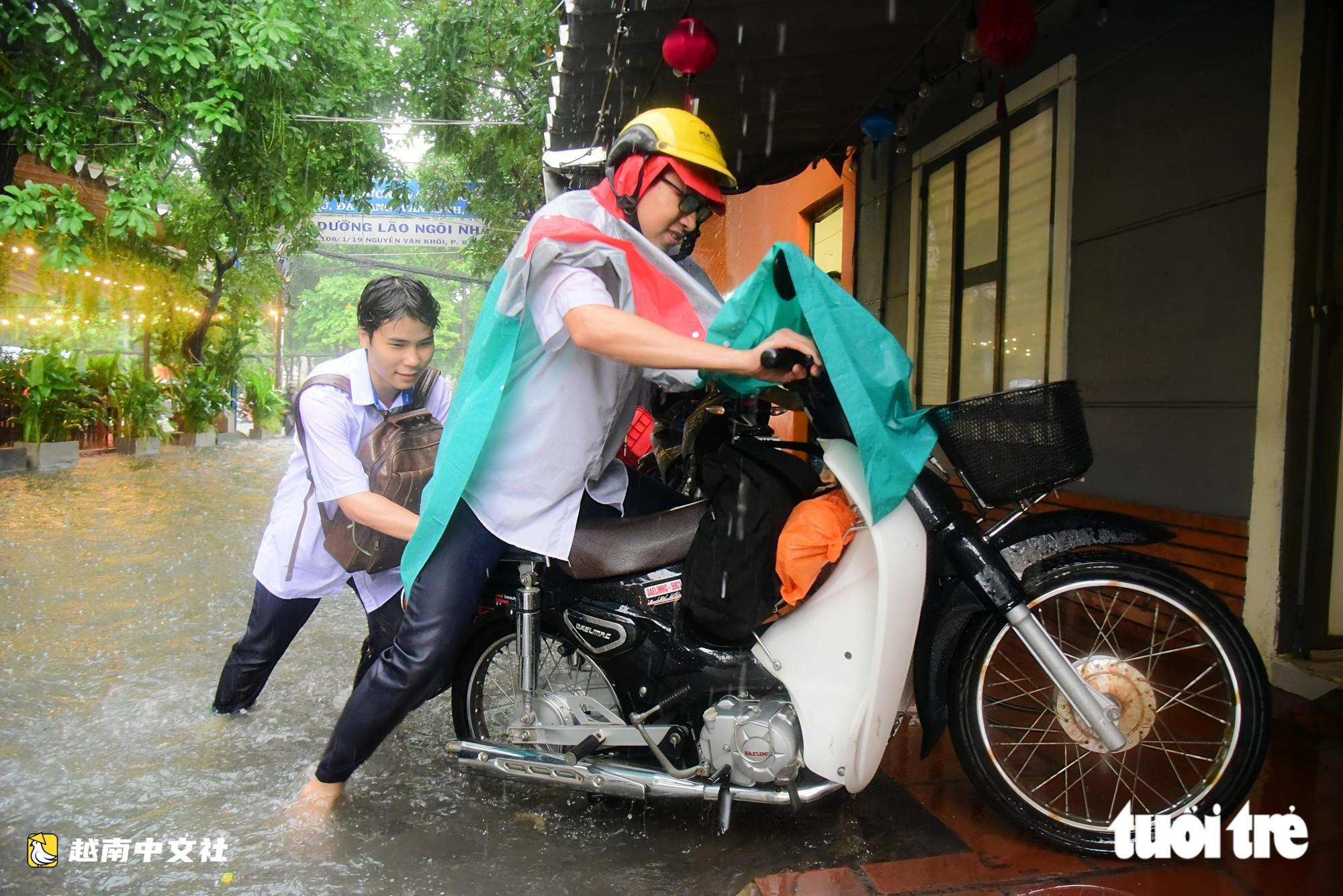 越南胡志明市阮文魁-黎文壽路口被淹,學生推車涉水回家