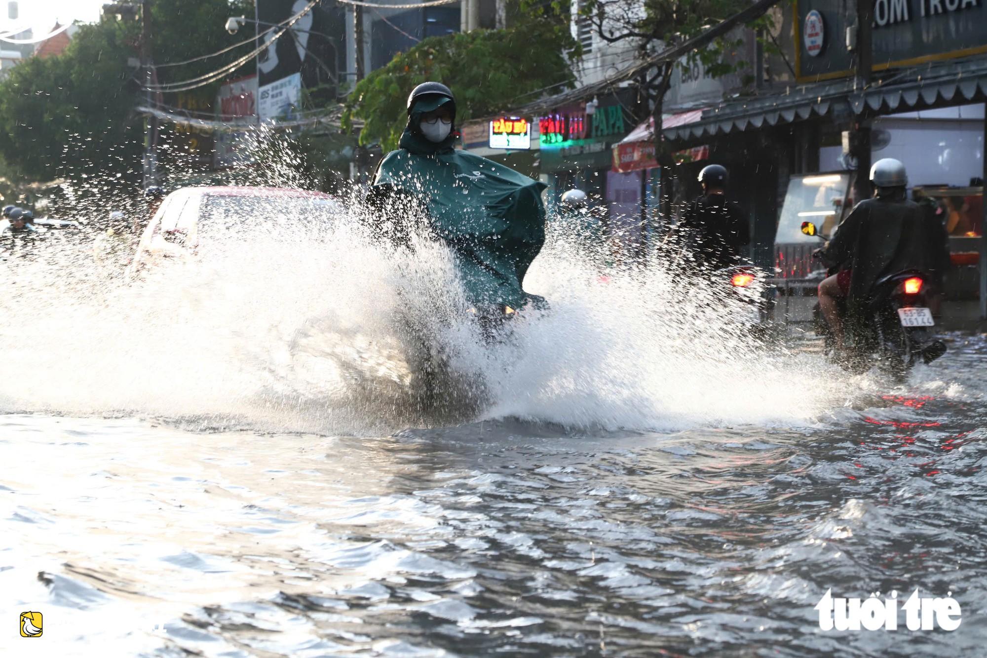 越南胡志明市阮文魁-黎文壽路口被淹,學生推車涉水回家
