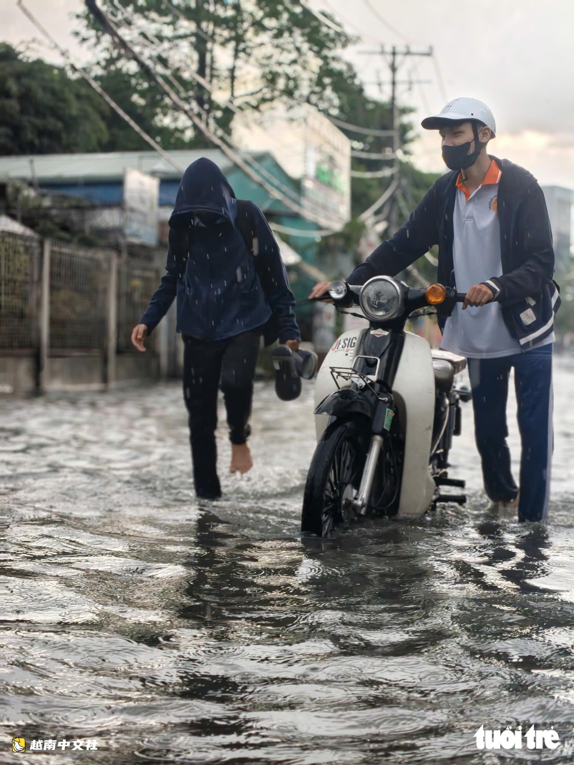越南胡志明市阮文魁-黎文壽路口被淹,學生推車涉水回家