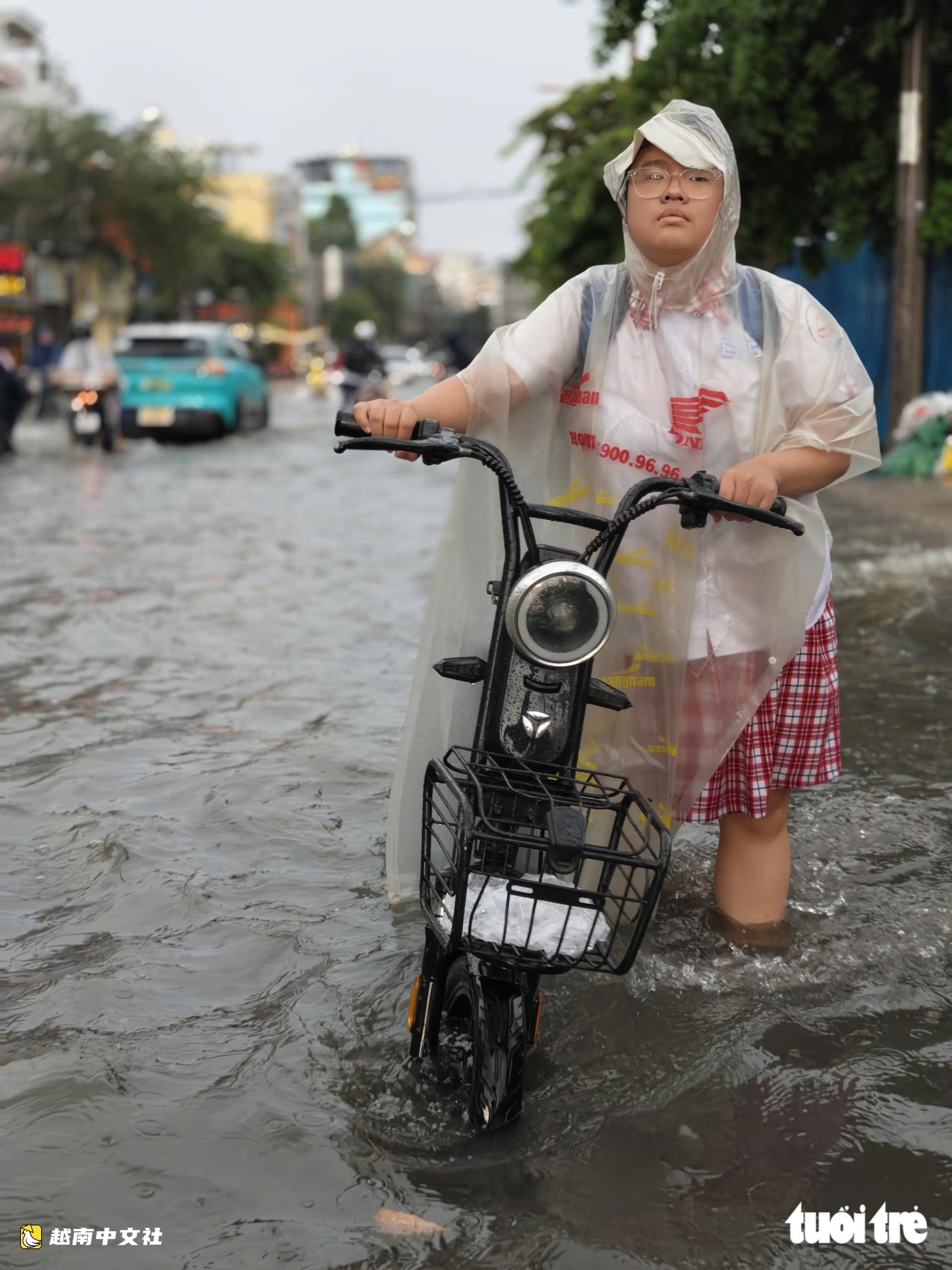 越南胡志明市阮文魁-黎文壽路口被淹,學生推車涉水回家