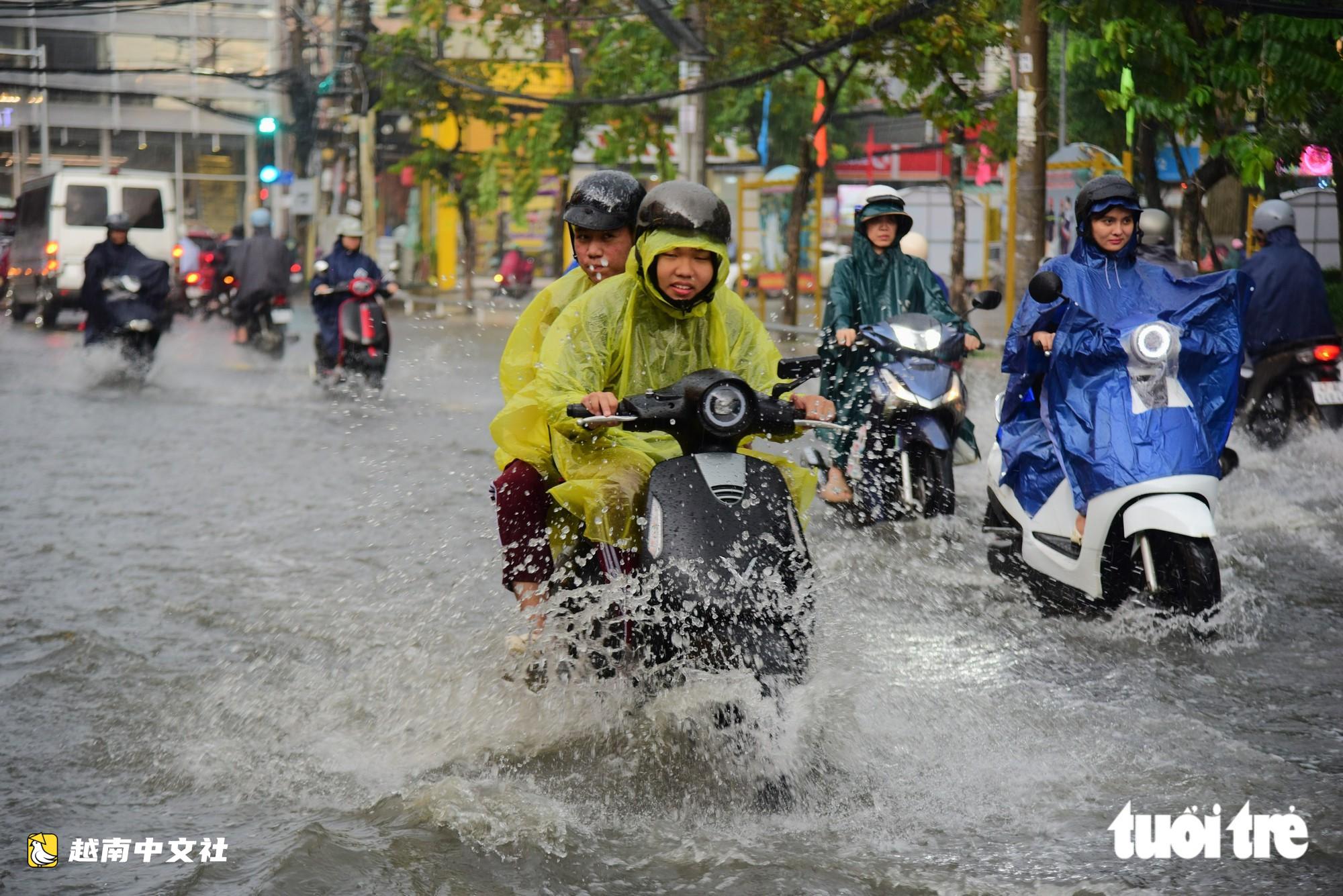 越南胡志明市阮文魁-黎文壽路口被淹,學生推車涉水回家