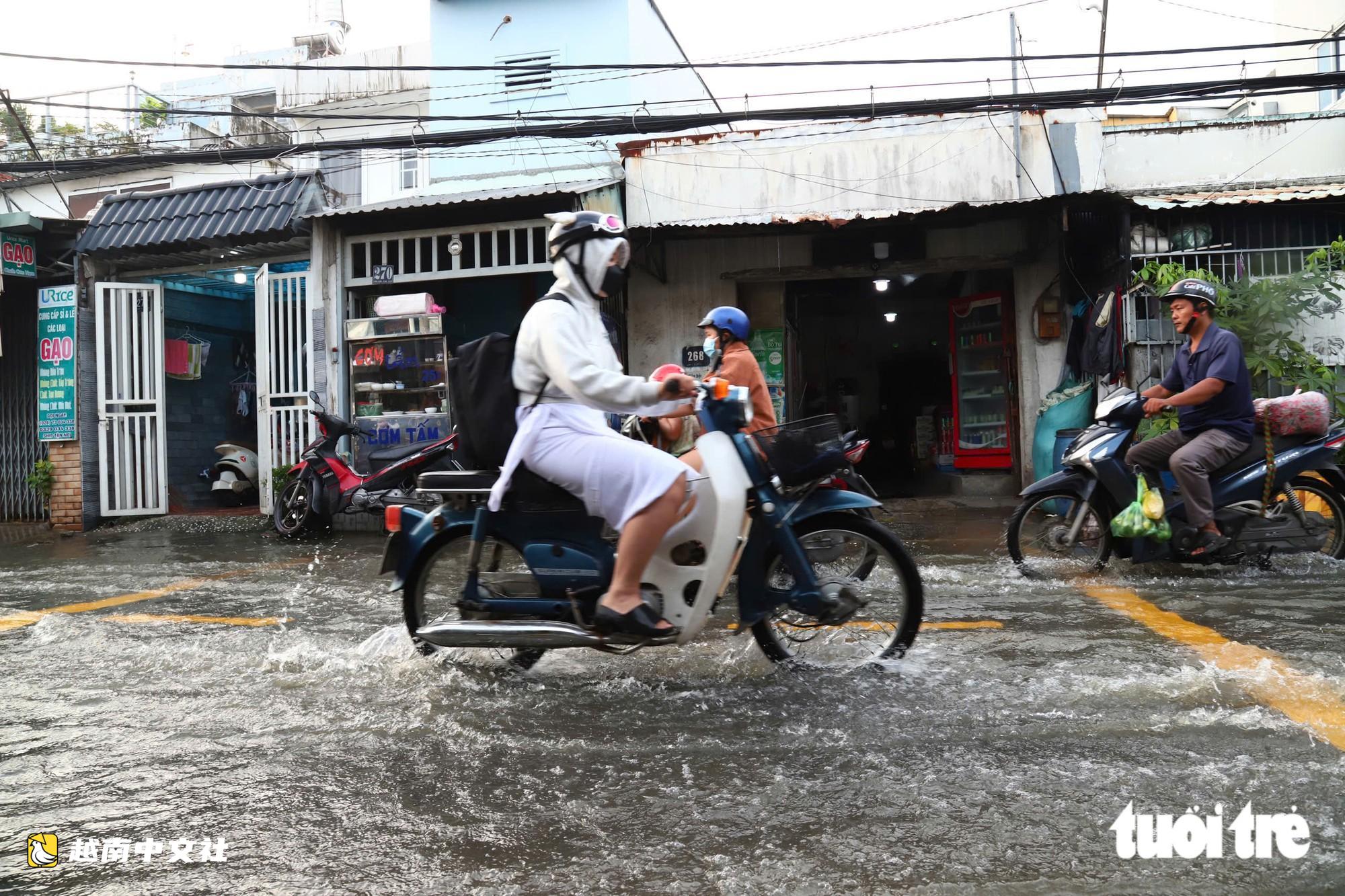 潮汐達到峰值,胡志明市市民繞道出行,學生捲起褲腿上學