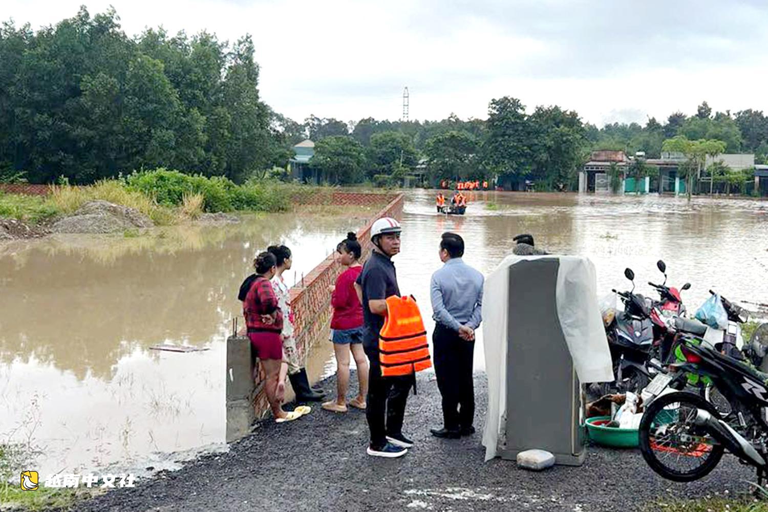越南同奈大雨漲潮,民眾清晨蹚水上班
