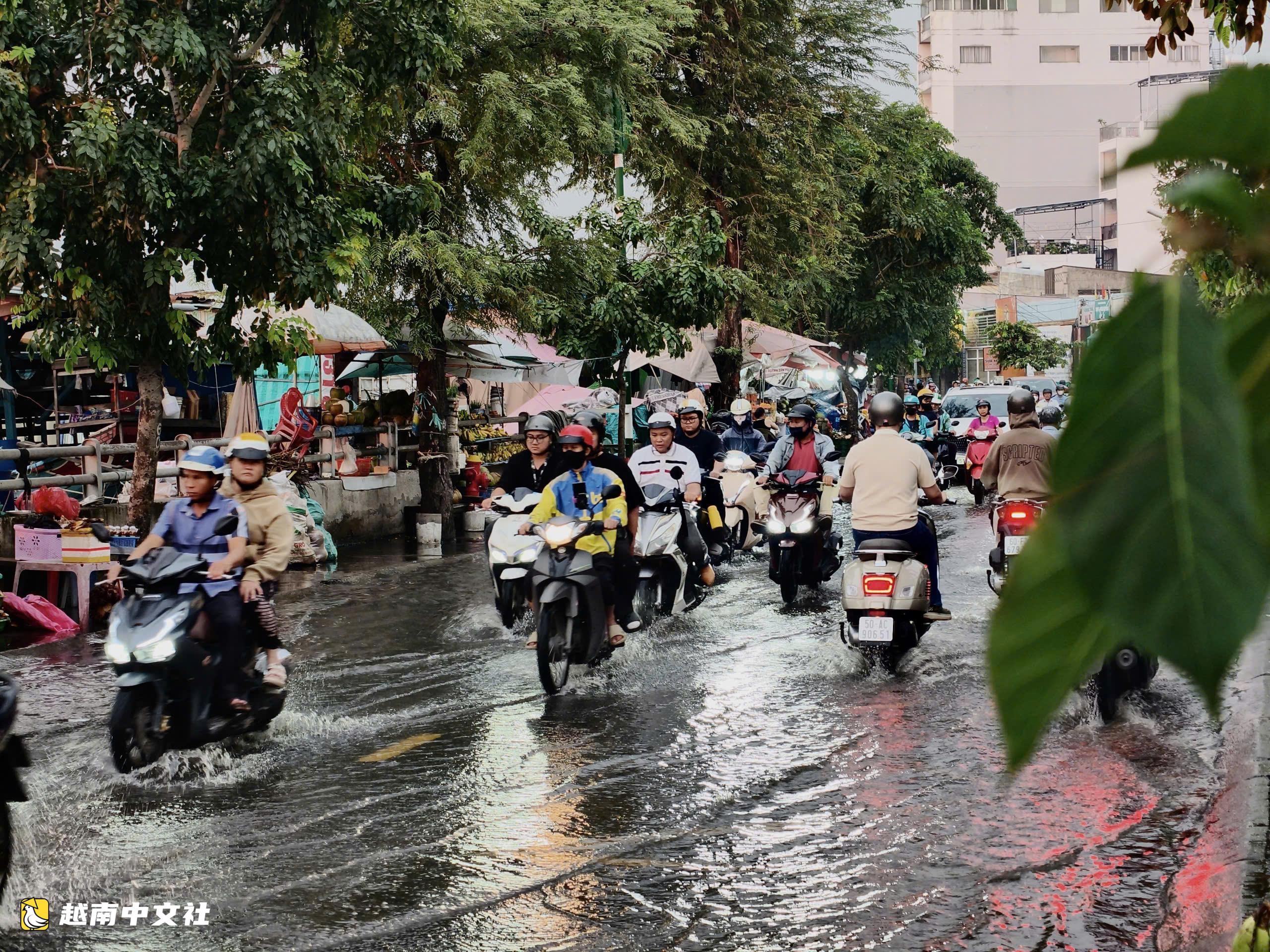 潮水上漲,胡志明市摩托車手探路避開坑窪