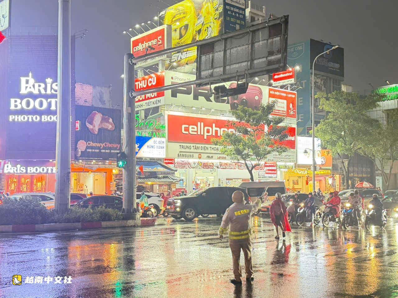 胡志明市交警冒雨分流，涉水幫民眾推摩托車過積水路段