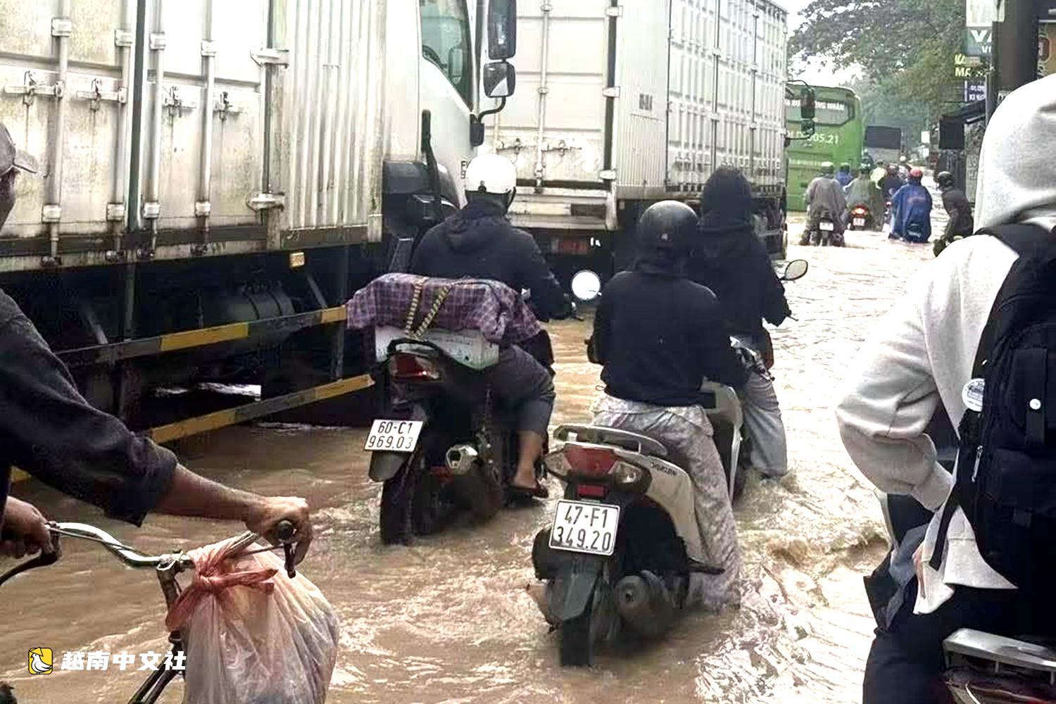 越南同奈大雨漲潮,民眾清晨蹚水上班