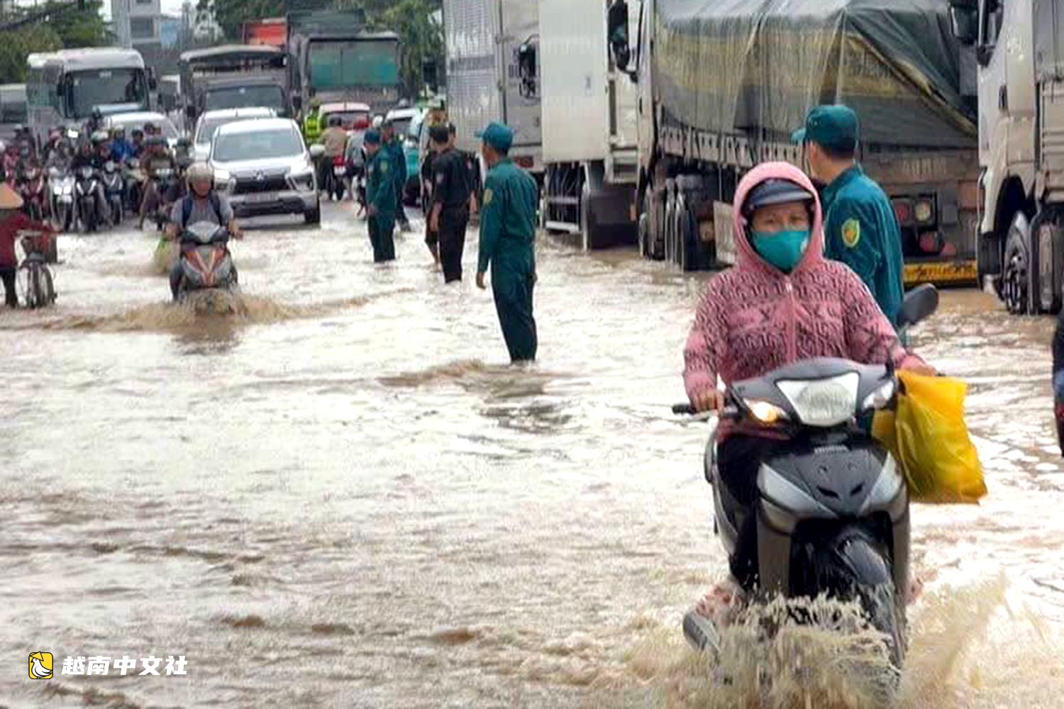 越南同奈大雨漲潮,民眾清晨蹚水上班