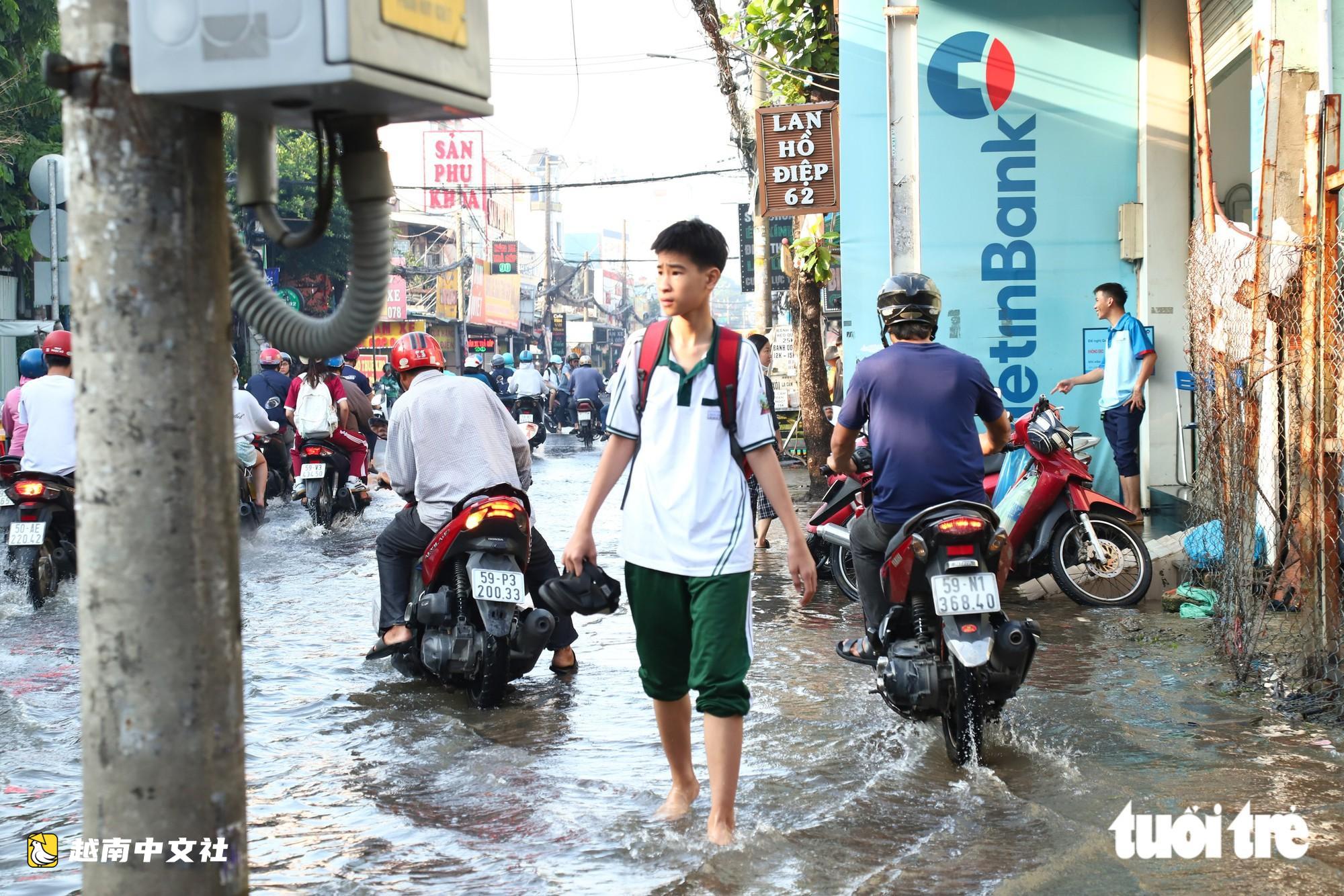 越南胡志明市創紀錄暴雨內澇後,潘輝益路積水退去,居民忙著清理家園