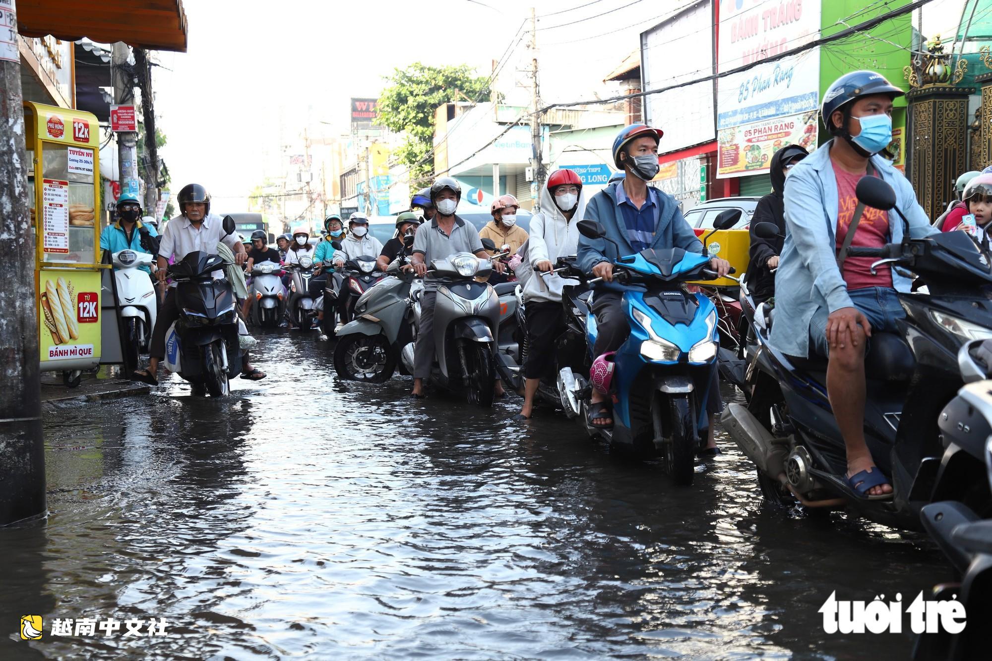 越南胡志明市創紀錄暴雨內澇後,潘輝益路積水退去,居民忙著清理家園