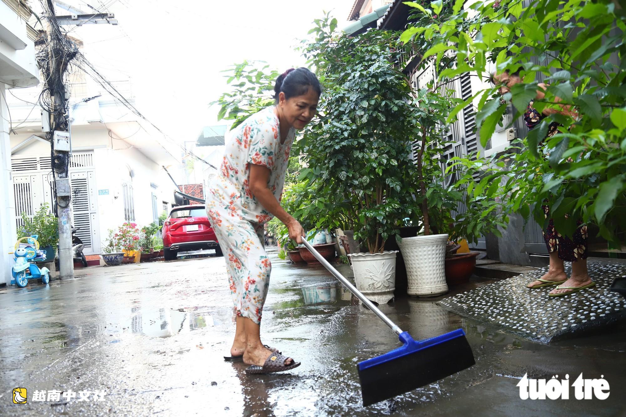 越南胡志明市創紀錄暴雨內澇後,潘輝益路積水退去,居民忙著清理家園