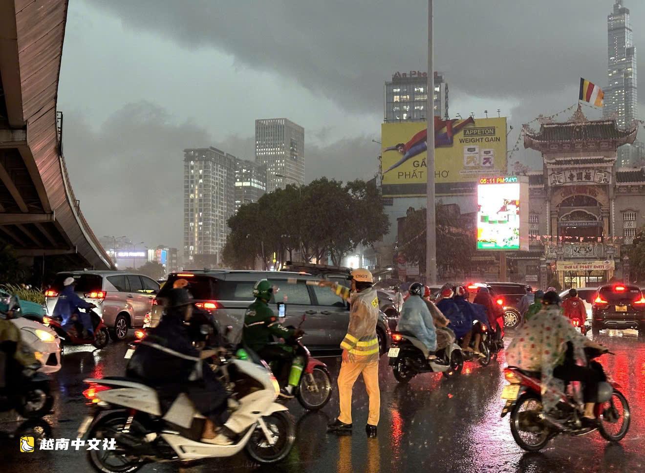 越南胡志明市交警提醒摩托車騎手:減速慢行、仔細觀察,不要強行穿越深水淹區