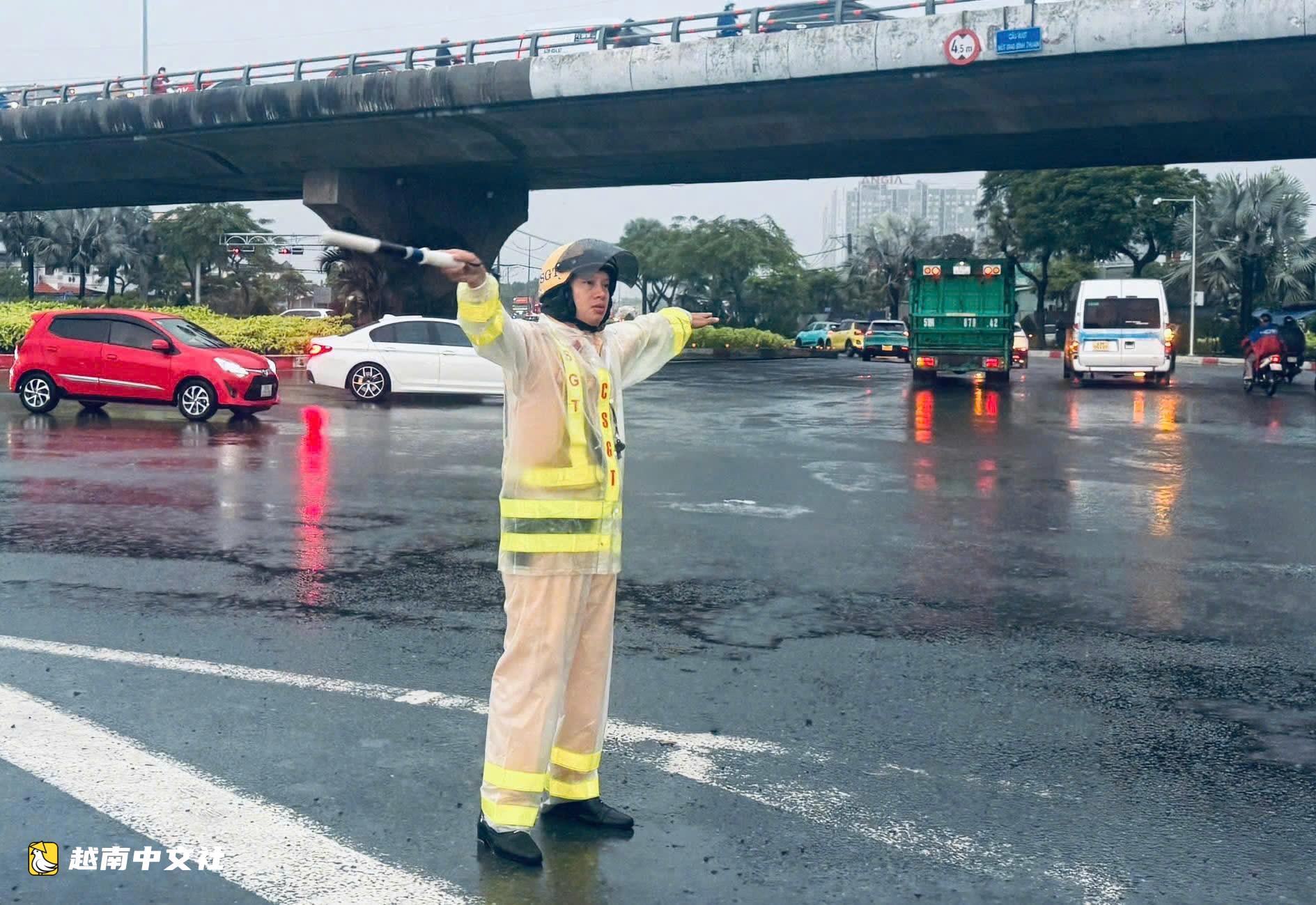 越南胡志明市交警提醒摩托車騎手:減速慢行、仔細觀察,不要強行穿越深水淹區