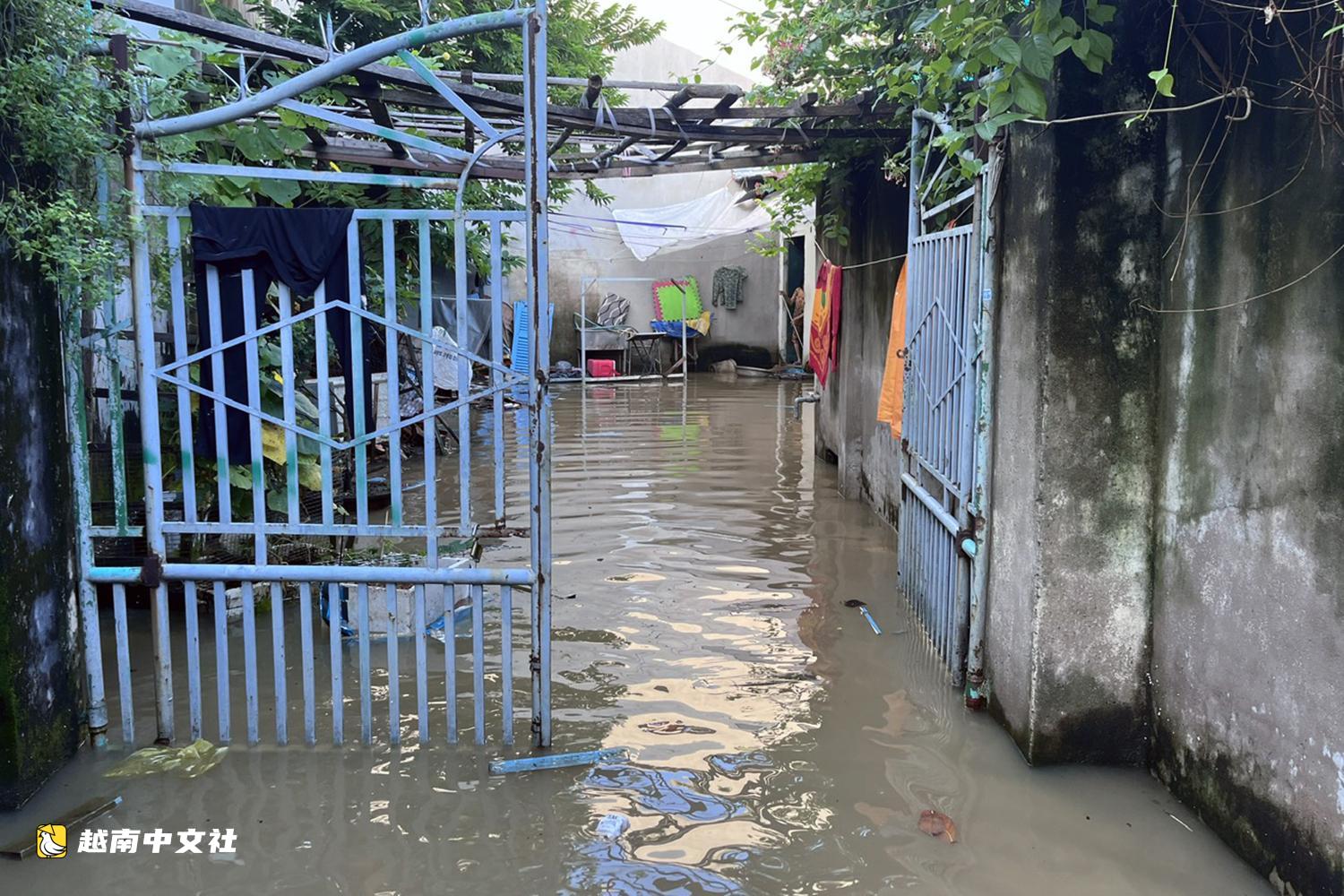 越南同奈河潮水上漲,低窪地區民眾蹚水出行