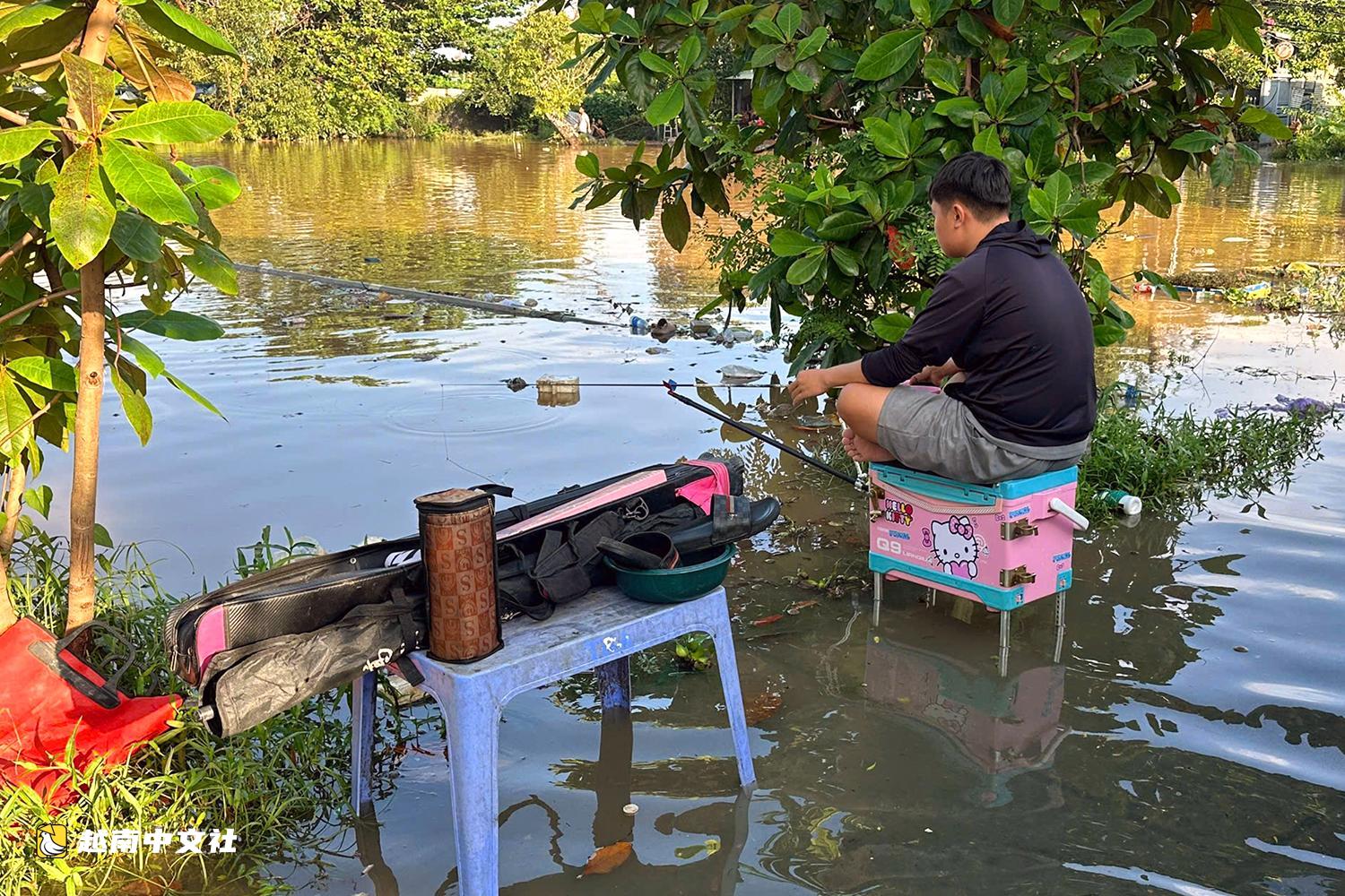 越南同奈河潮水上漲,低窪地區民眾蹚水出行