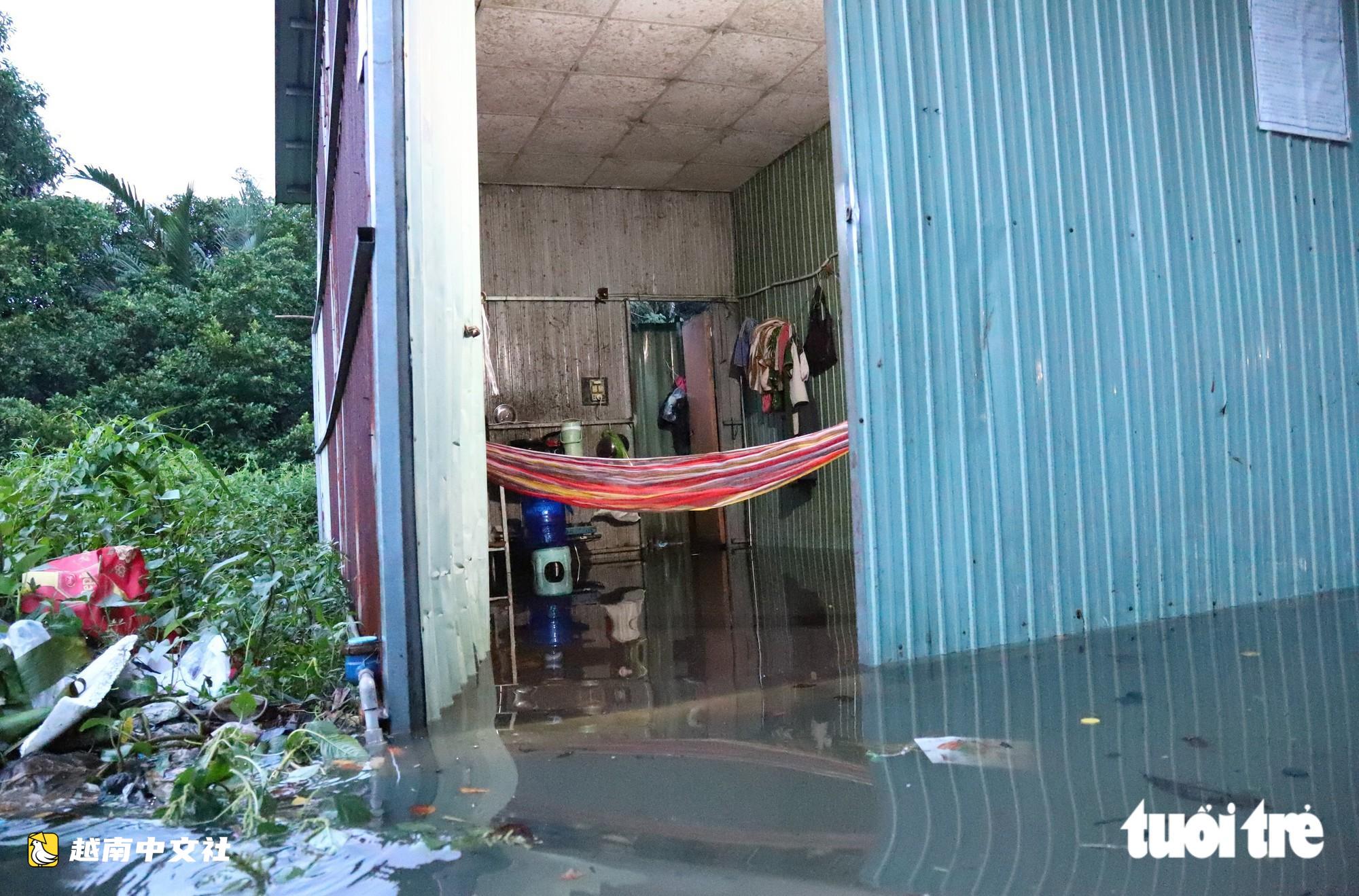 胡志明市潮水達峰,民眾在門前築‘堤’,兒童在潮水中游泳
