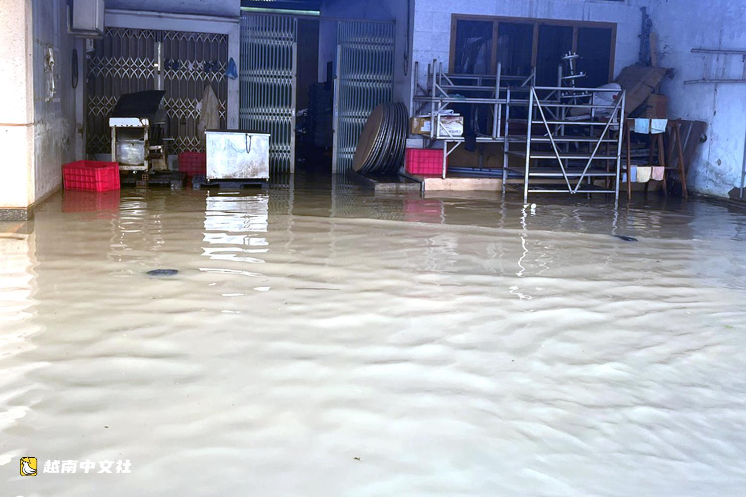 越南同奈河潮水上漲,低窪地區民眾蹚水出行