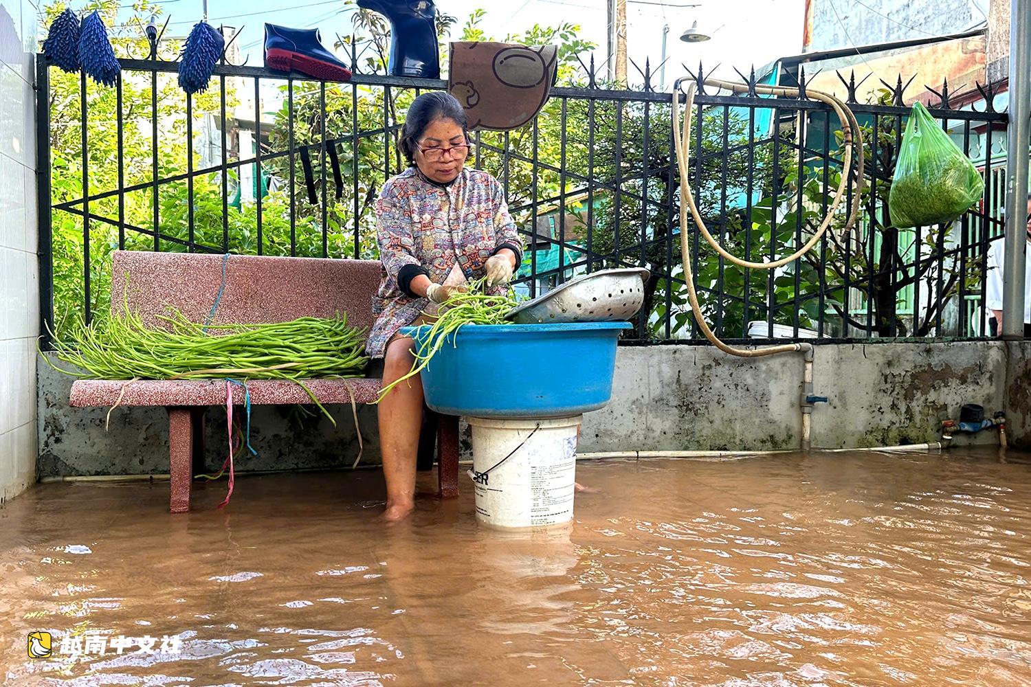 越南同奈河潮水上漲,低窪地區民眾蹚水出行