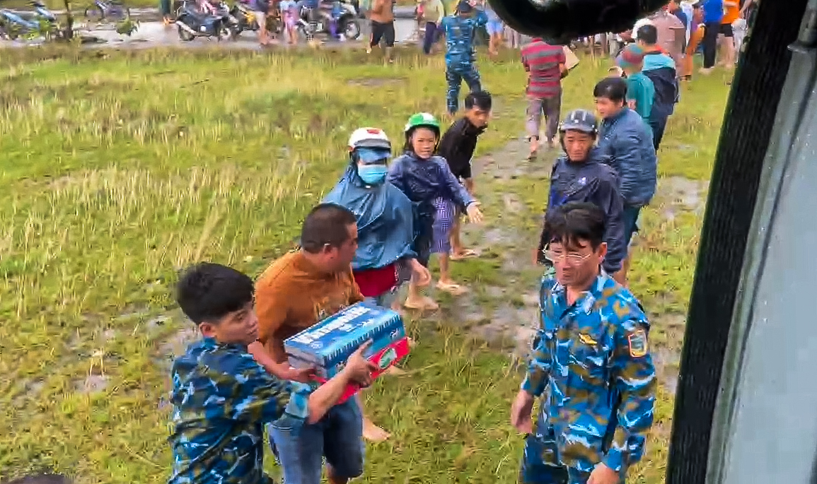 富安省旧地居民涌向第917团直升机降落点接收紧急救援物资