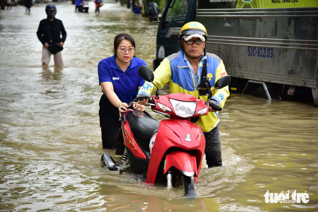 潮汐越过Thanh Đa的屏障，在Hiệp Phước淹没半辆车