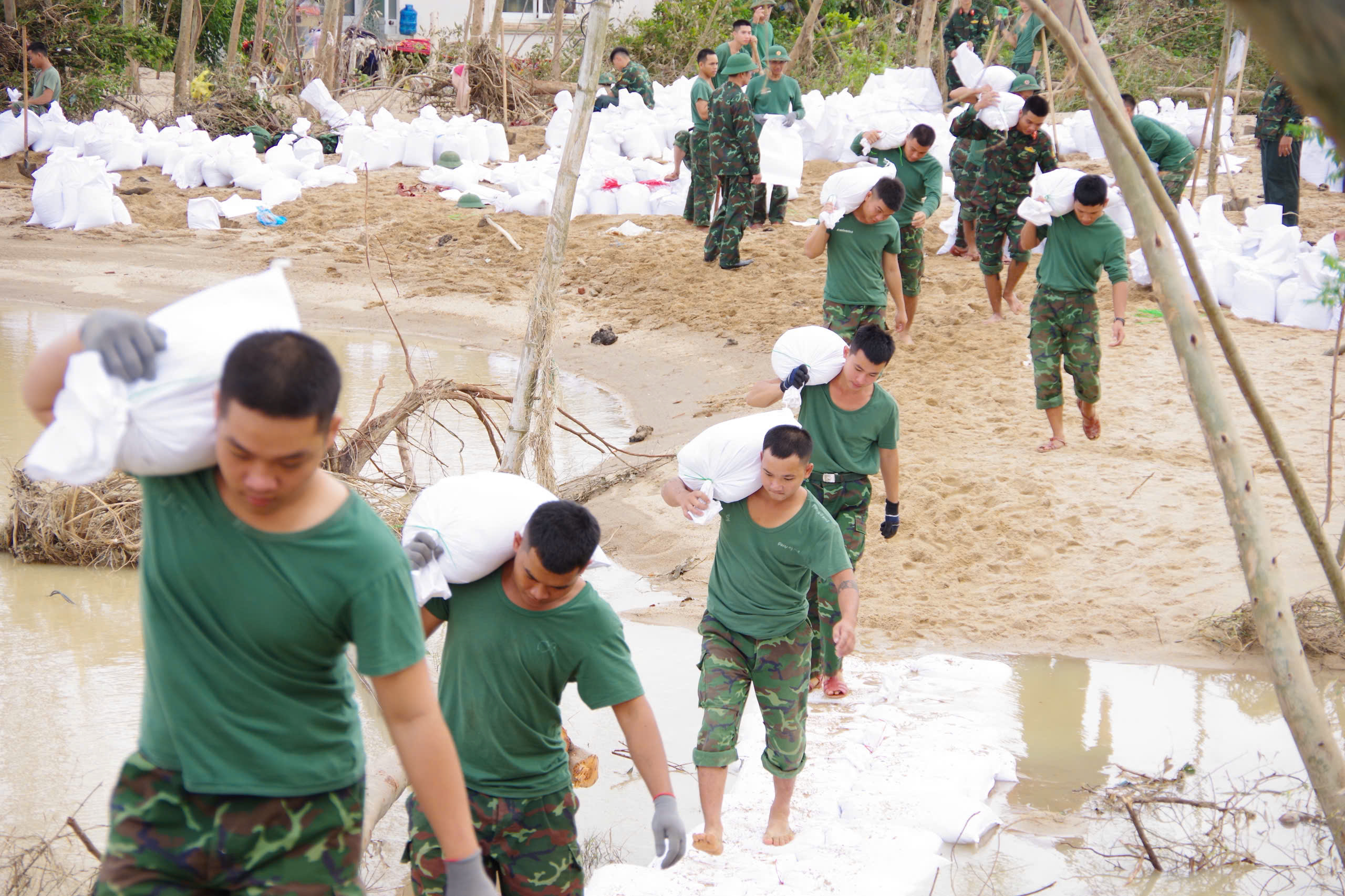 嘉莱省100多名士兵与地方力量用沙袋修补决堤段