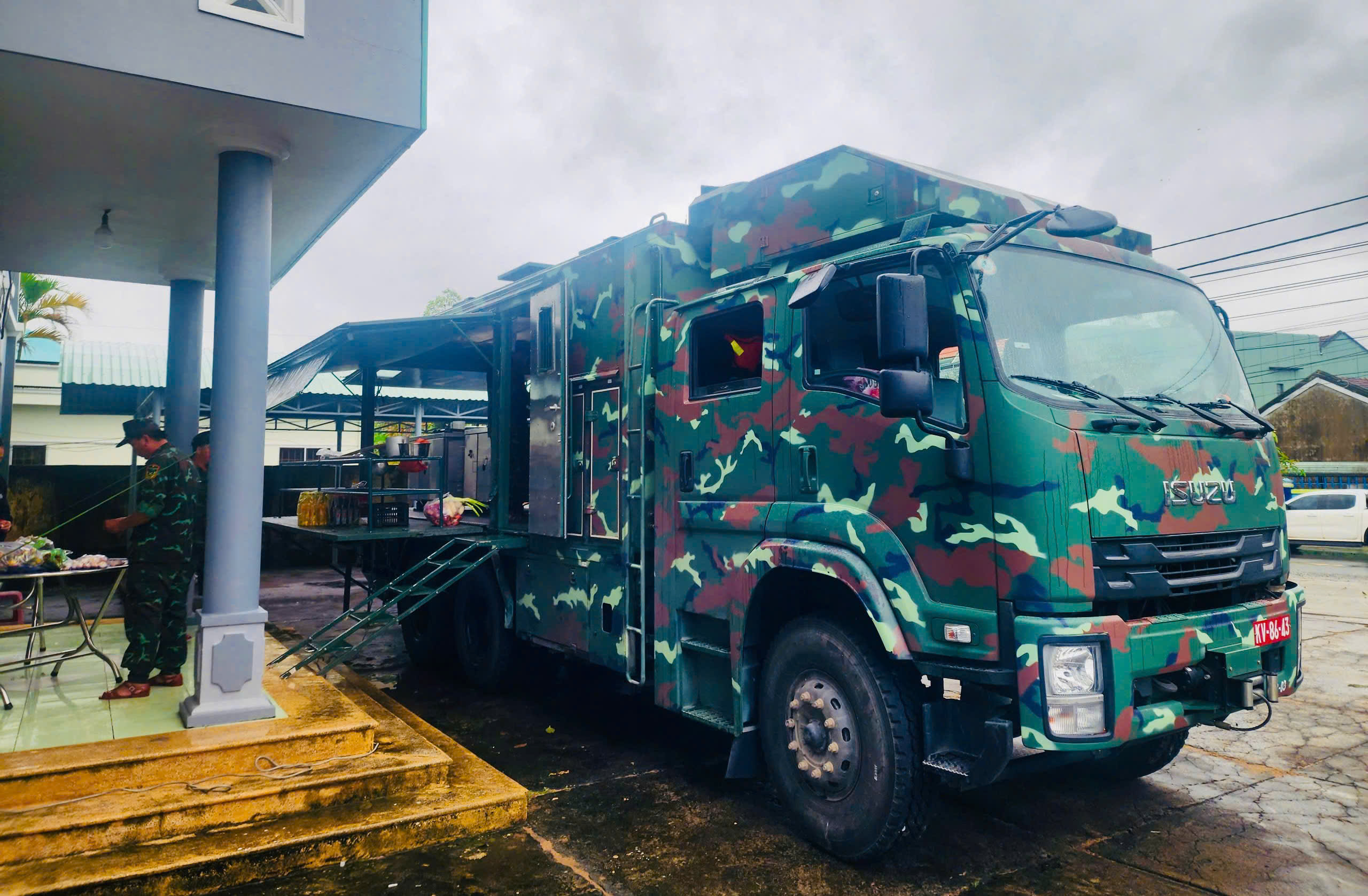 第五军区作战炊事车前往洪水灾区，战士为民众烹饪热饭