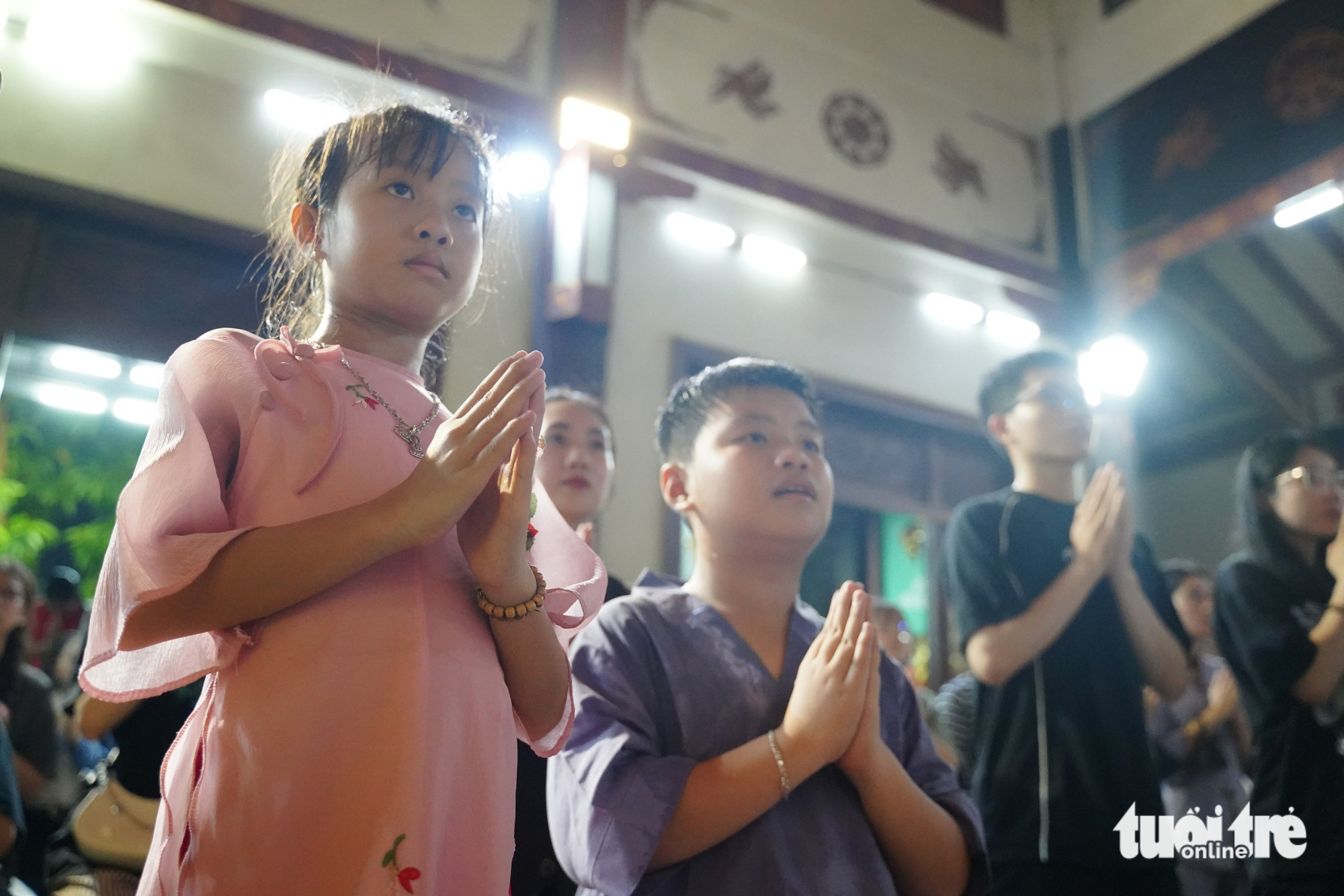 胡志明市市民冒雨在盂兰节期间参拜寺庙