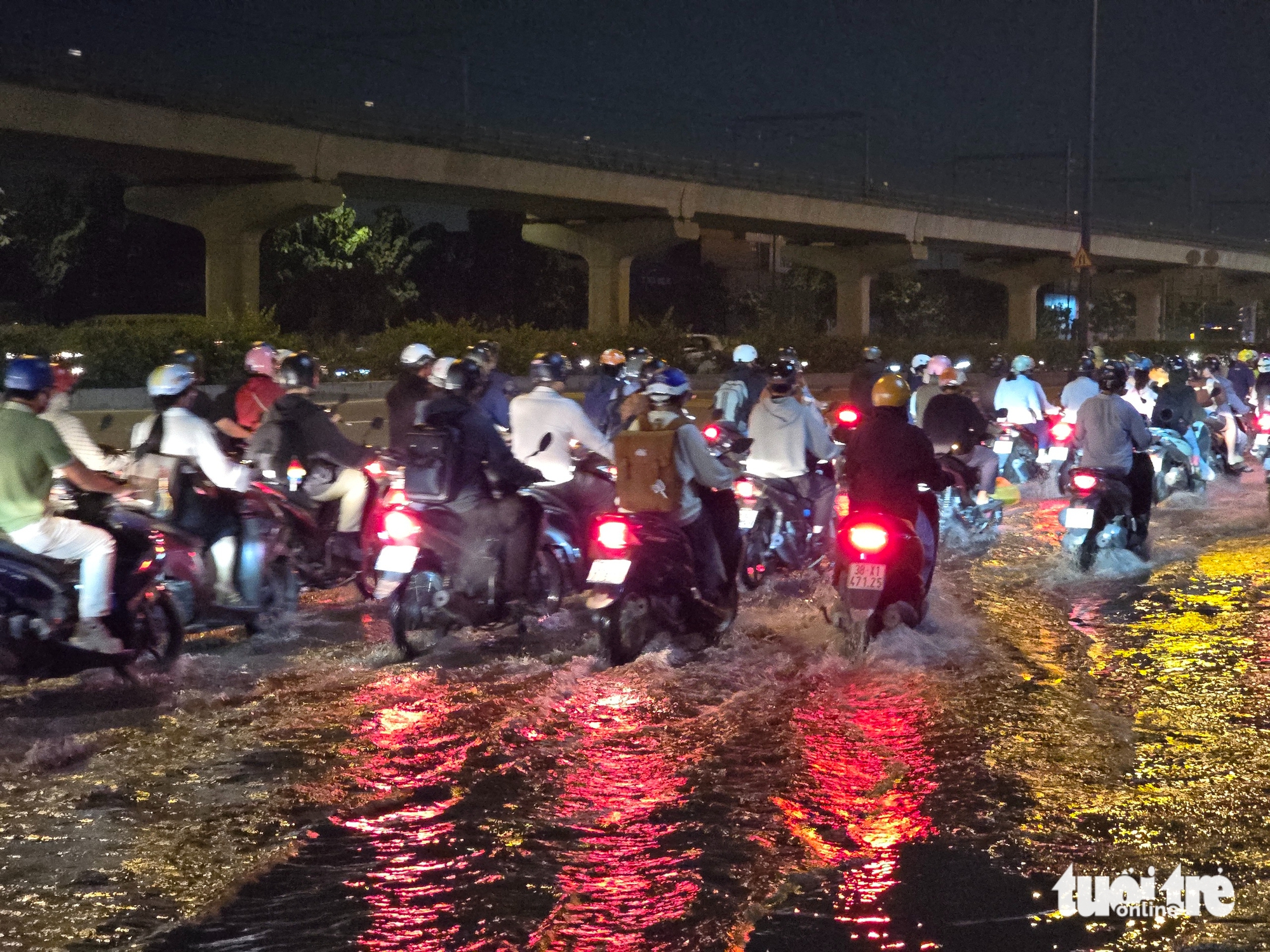 潮汐导致武元甲路下水道水漫路面，数千摩托车缓慢通过积水路段