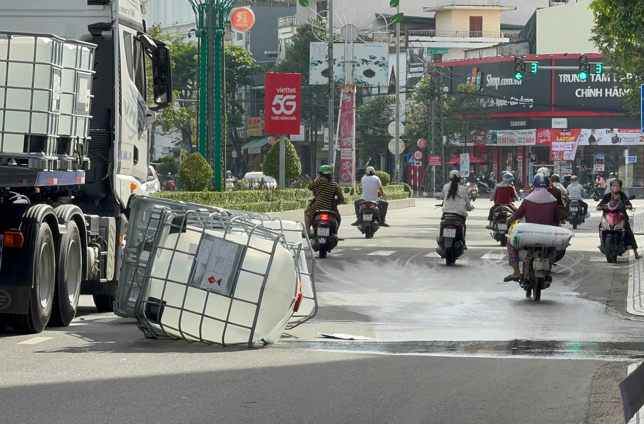 四个塑料桶装冰醋酸掉落街道，散发气味，居民感到恶心