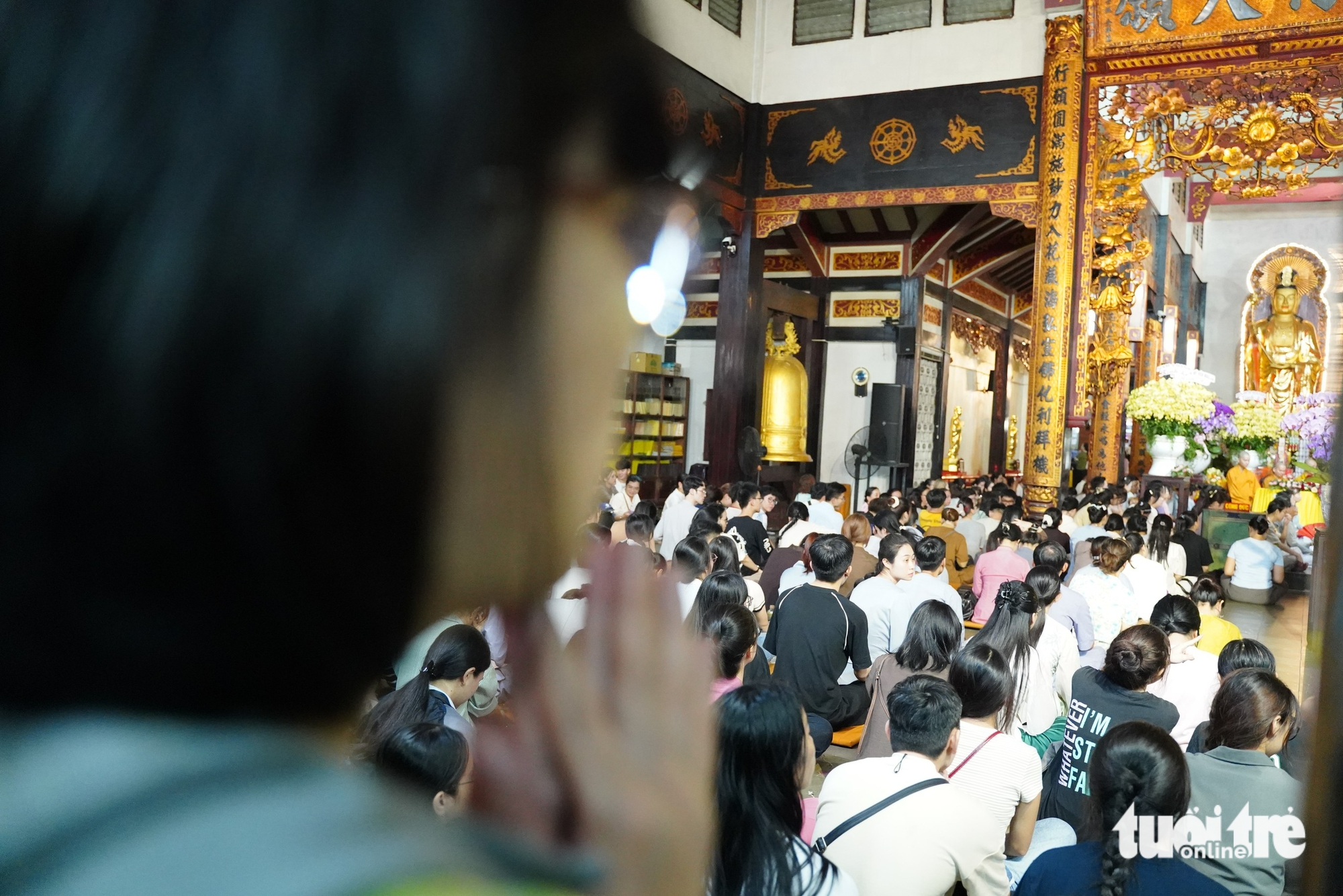 胡志明市市民冒雨在盂兰节期间参拜寺庙