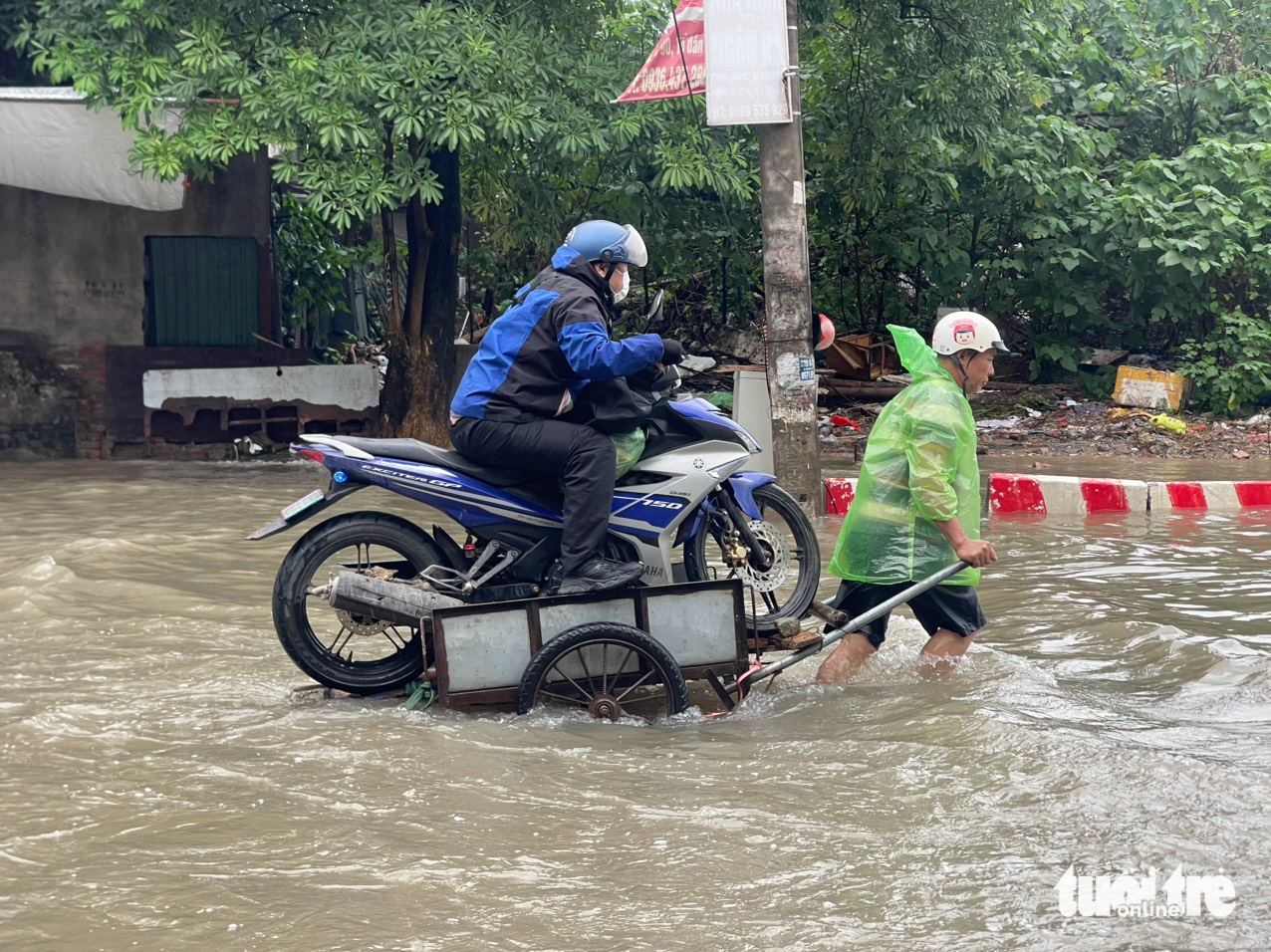 繁忙'救援'摩托车通过积水点，价格...20万越南盾行驶百余米